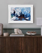 Framed abstract painting on a wall above a wooden console table with decorative items.