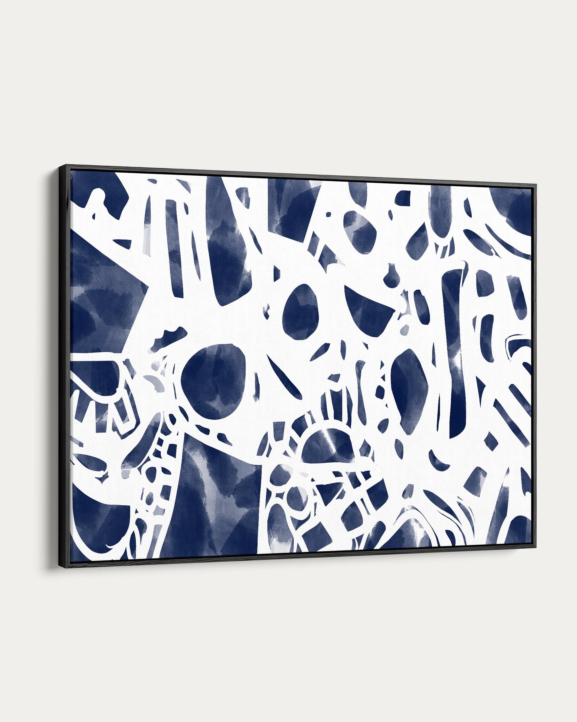 Framed abstract art print with blue and white pattern on a white wall