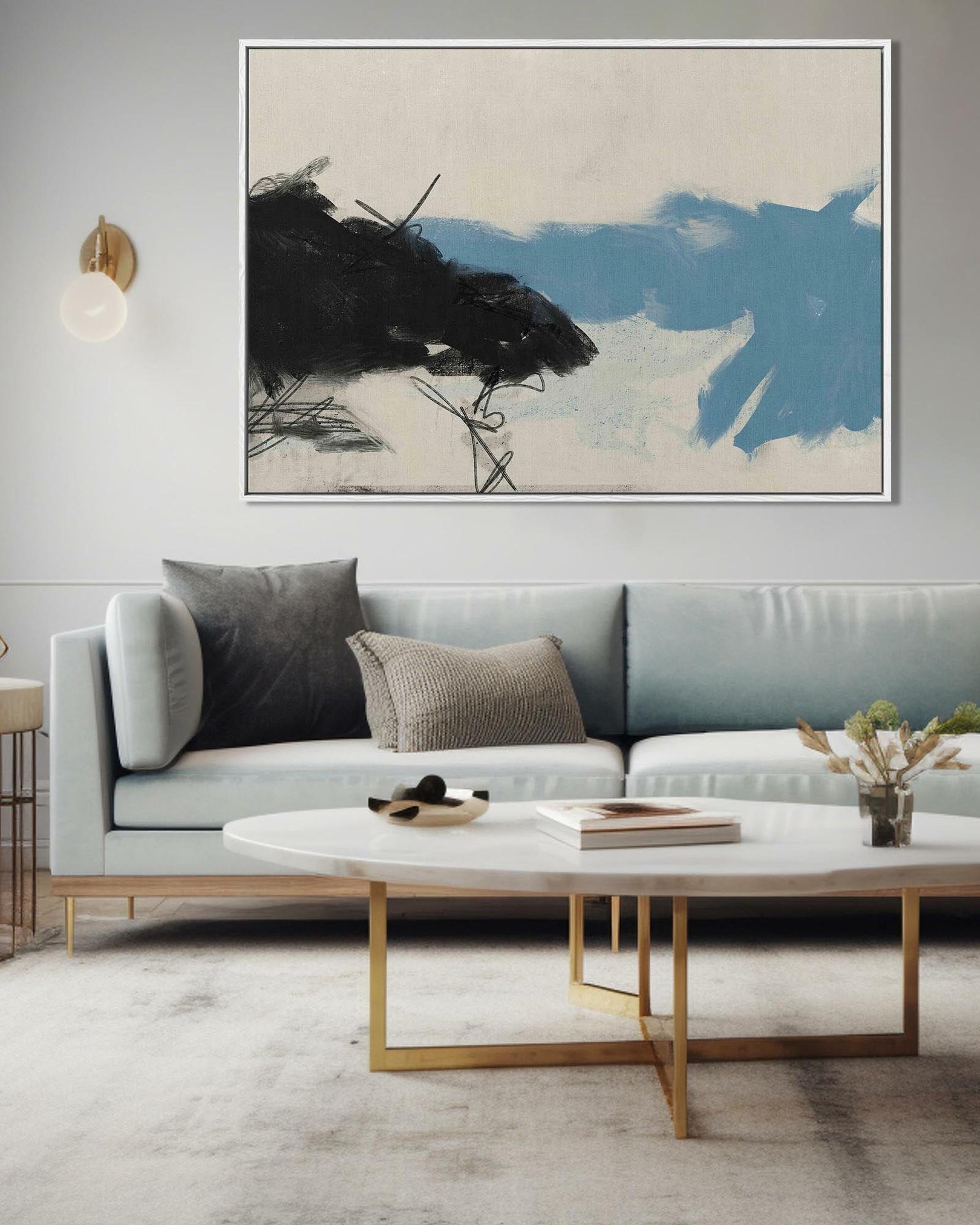 Modern living room with a gray sofa, abstract painting, and gold coffee table.