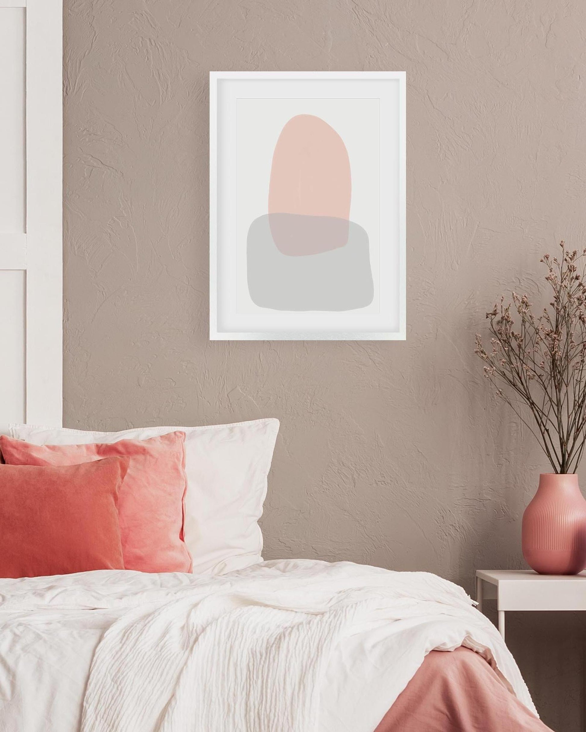 Abstract art print on a wall above a bed with pink and white bedding.