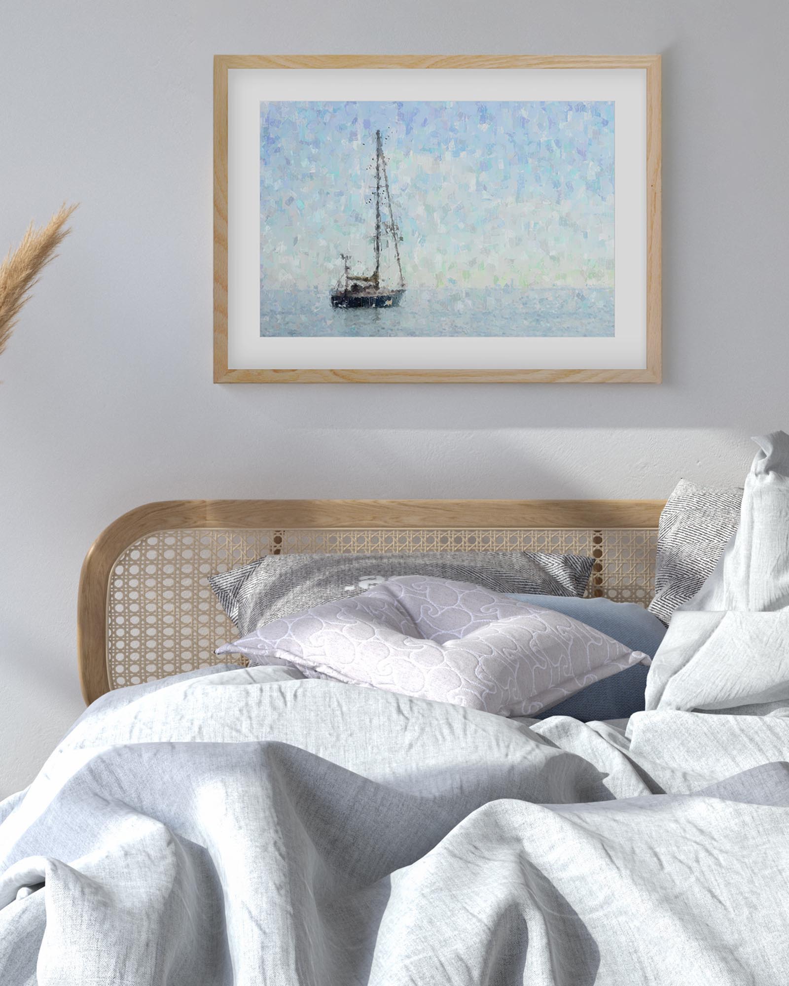 Framed artwork of a sailboat on a wall above a bed with white bedding.