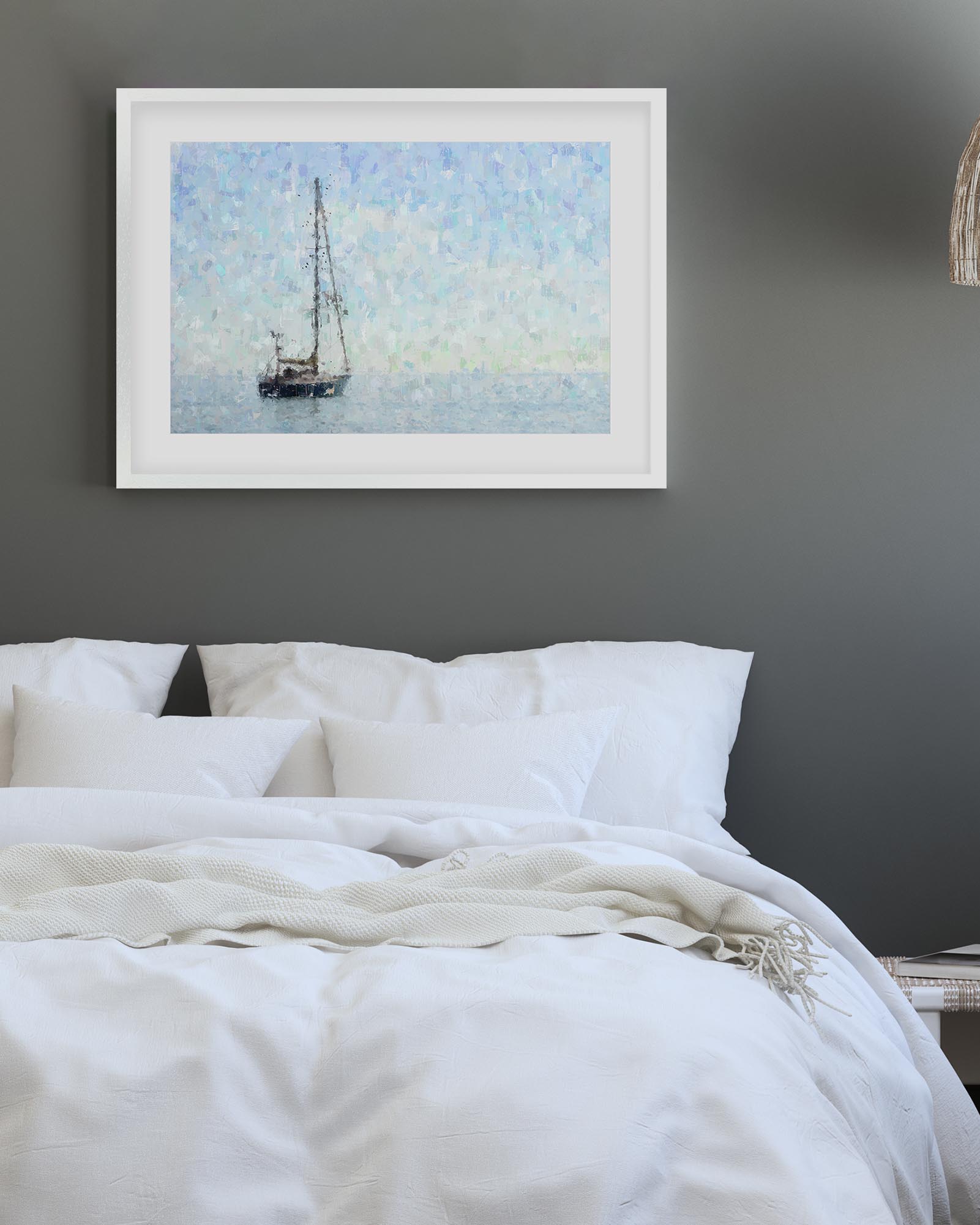 Framed artwork of a sailboat on a gray wall above a bed with white bedding.