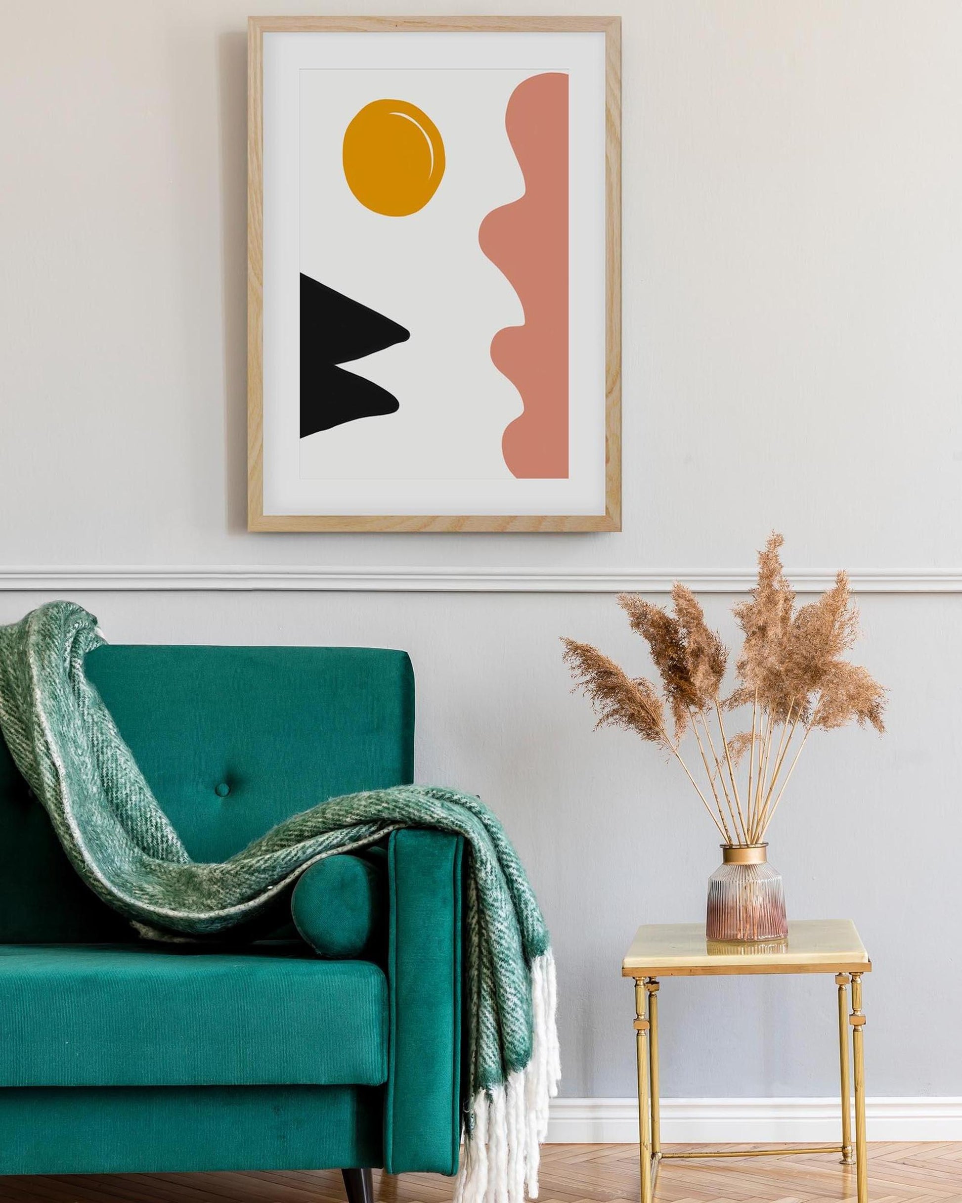 Modern interior with a teal armchair, abstract art, and decorative elements.