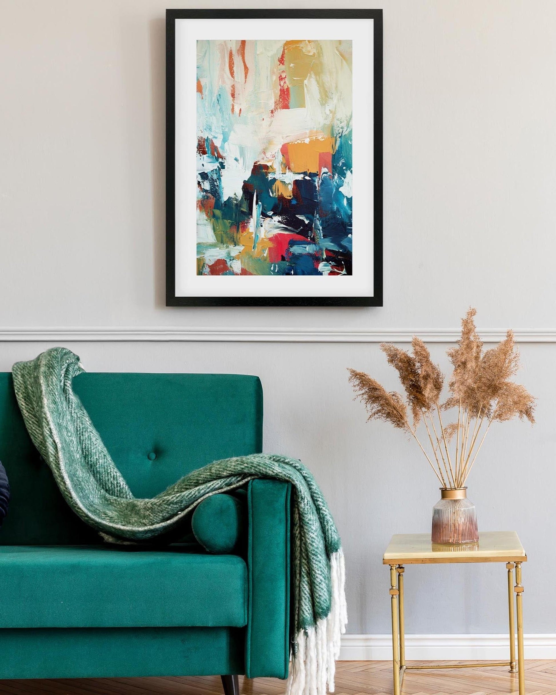 colourful framed abstract print in living room above green sofa