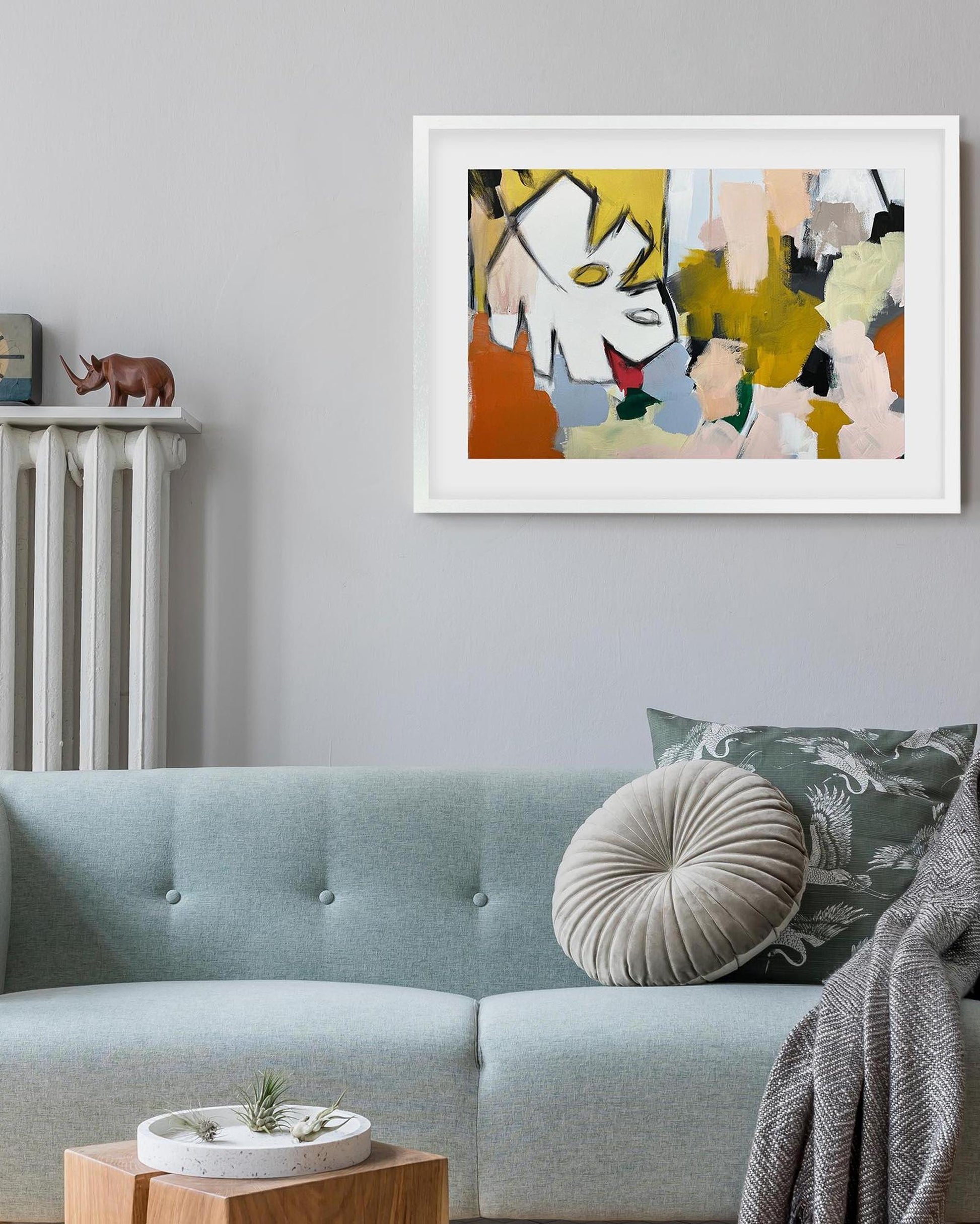 Abstract art print on a wall above a sofa in a living room