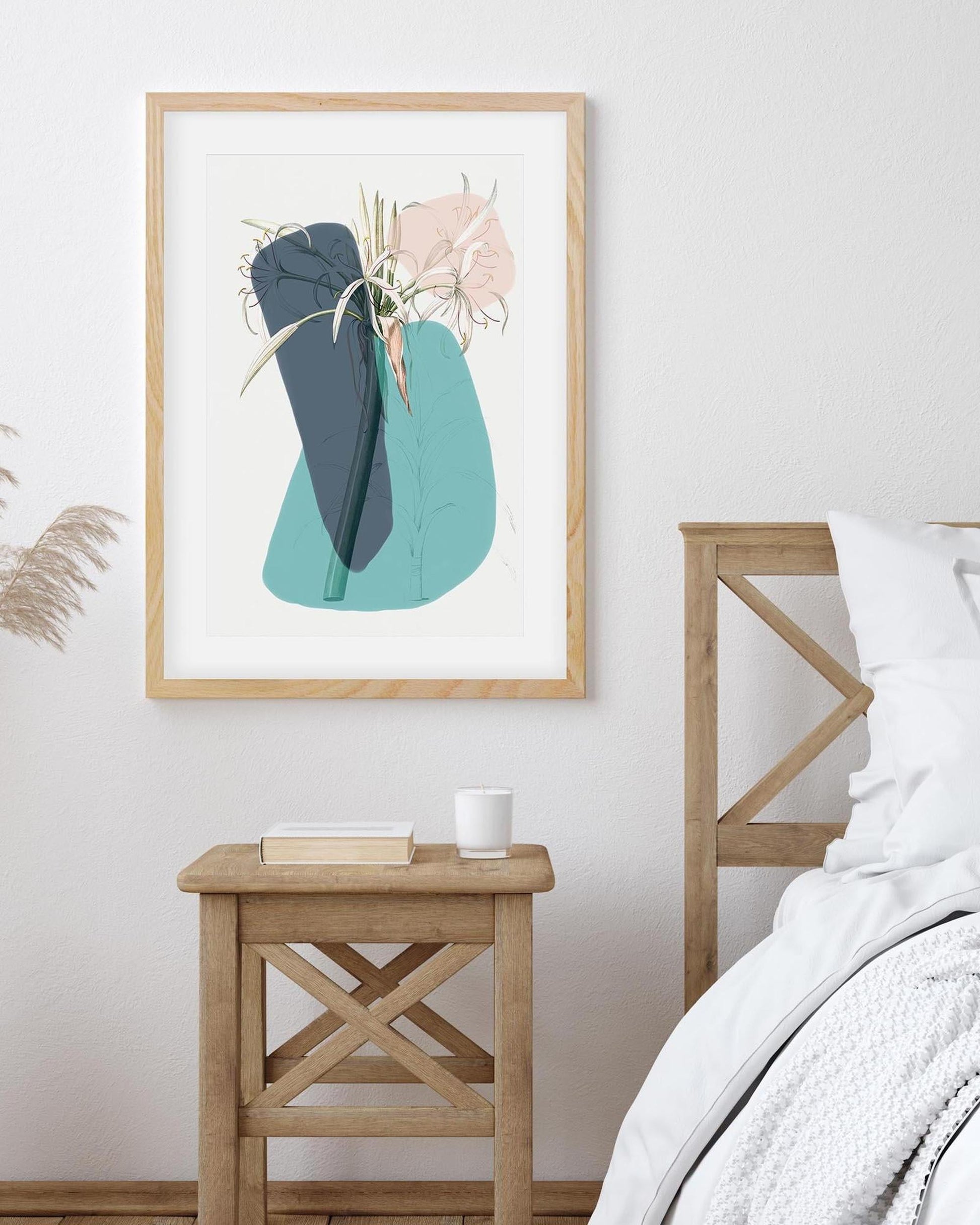 Framed abstract art print on a wall above a wooden side table in a bedroom.