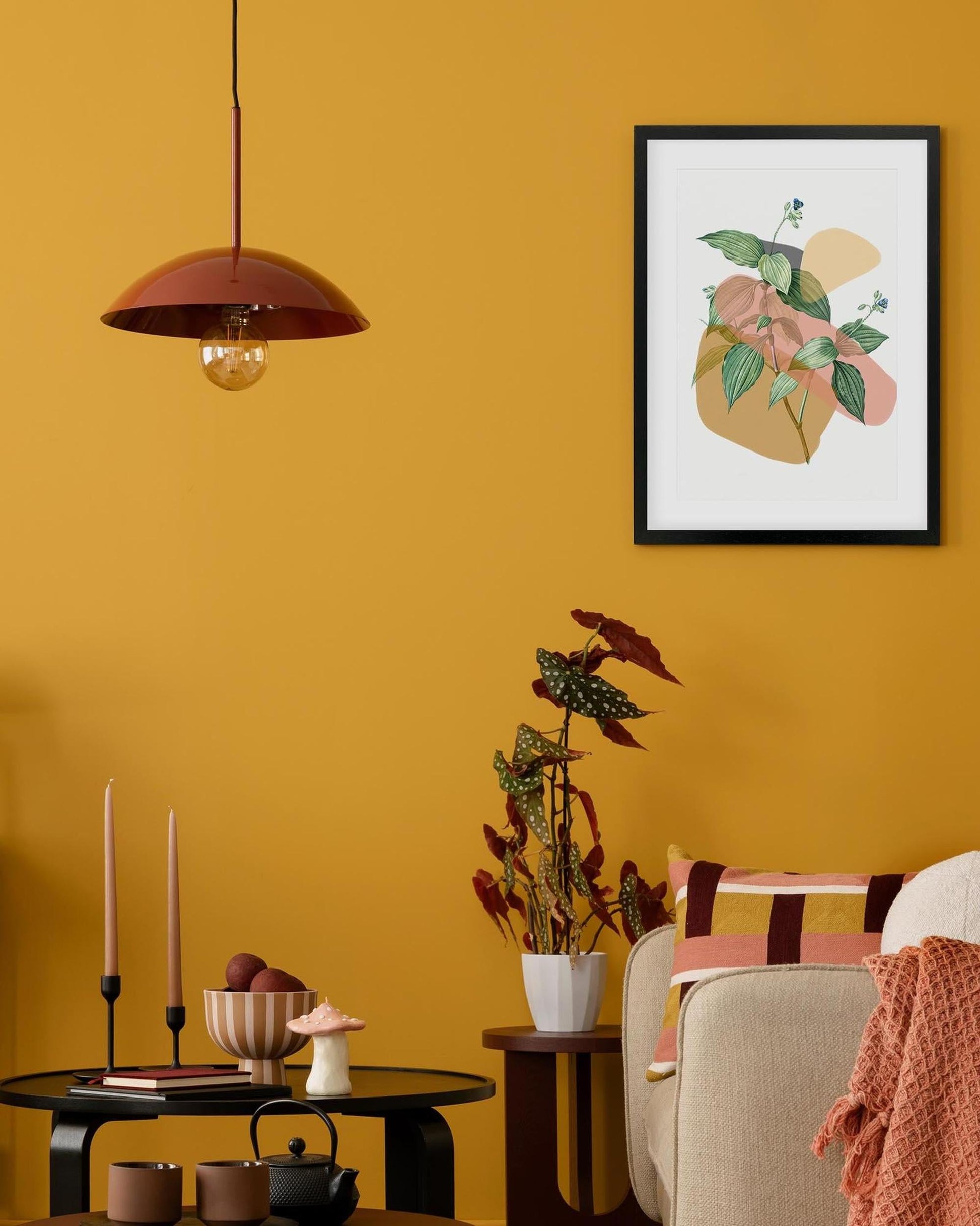 Living room with a yellow wall, framed artwork, and decorative items.