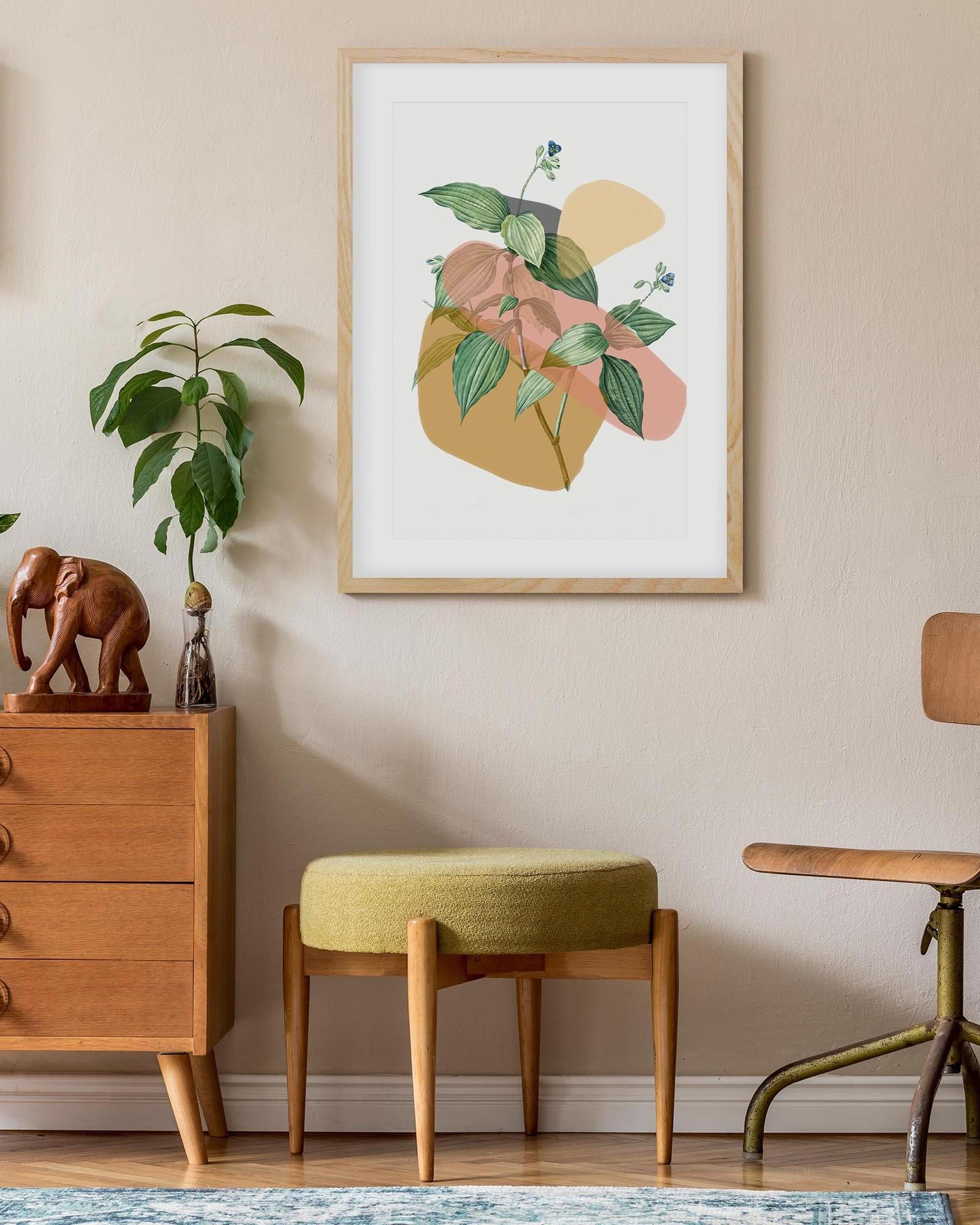 Framed floral art on a wall above a wooden cabinet with decorative items.