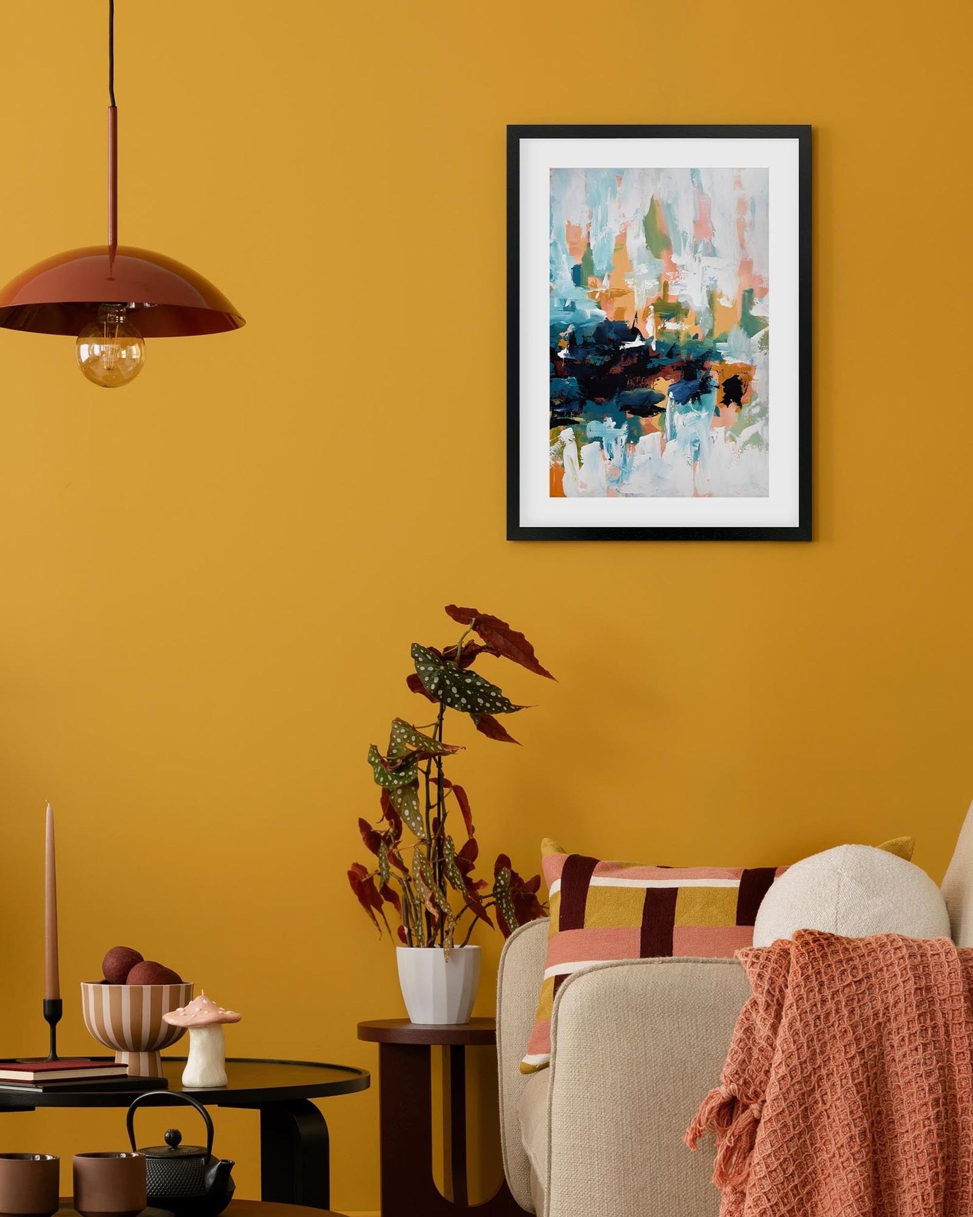 Living room with yellow walls, a framed abstract painting, and decorative items.