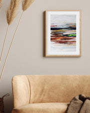Abstract painting on a wall above a beige sofa with decorative elements.