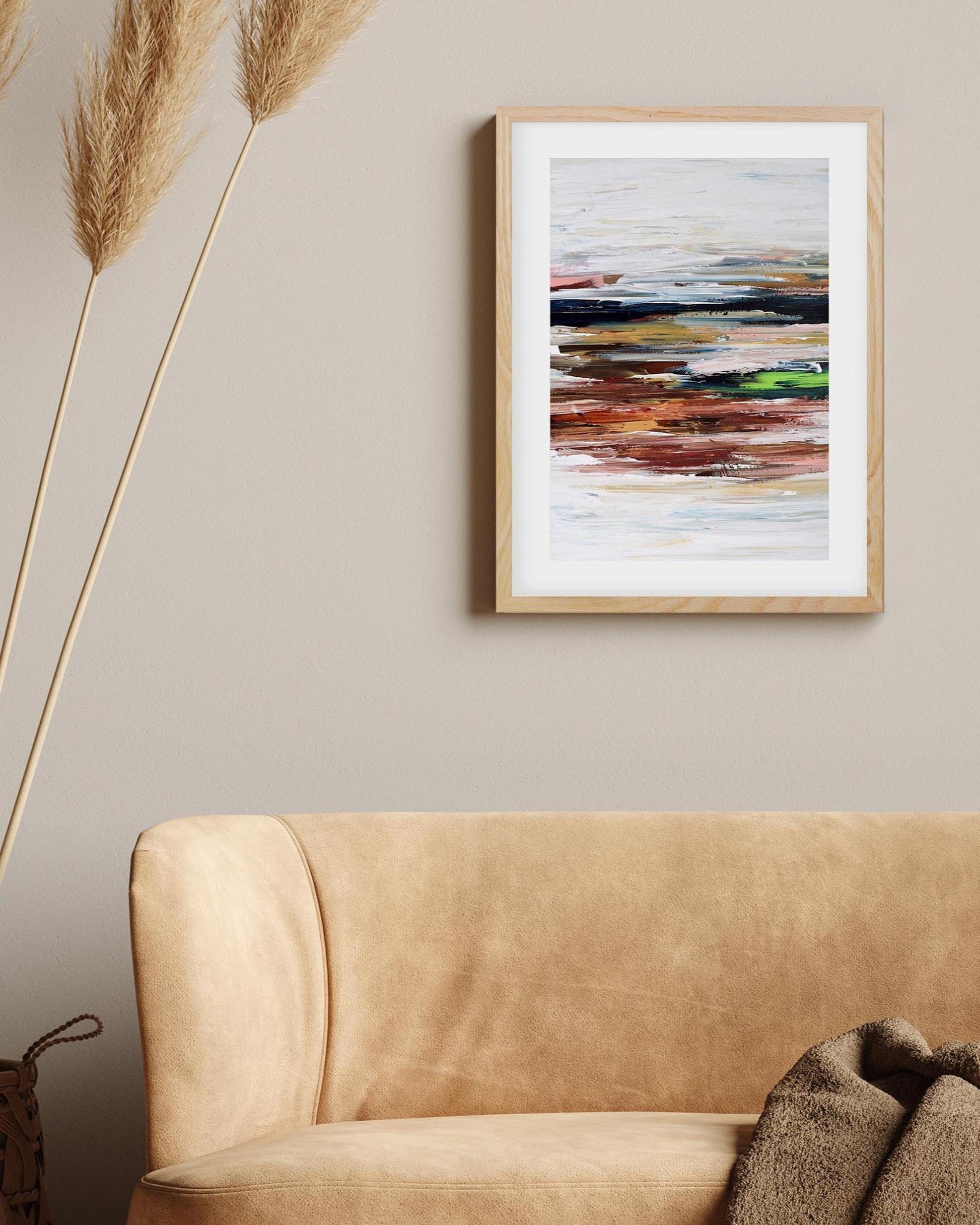Abstract painting on a wall above a beige sofa with decorative elements.