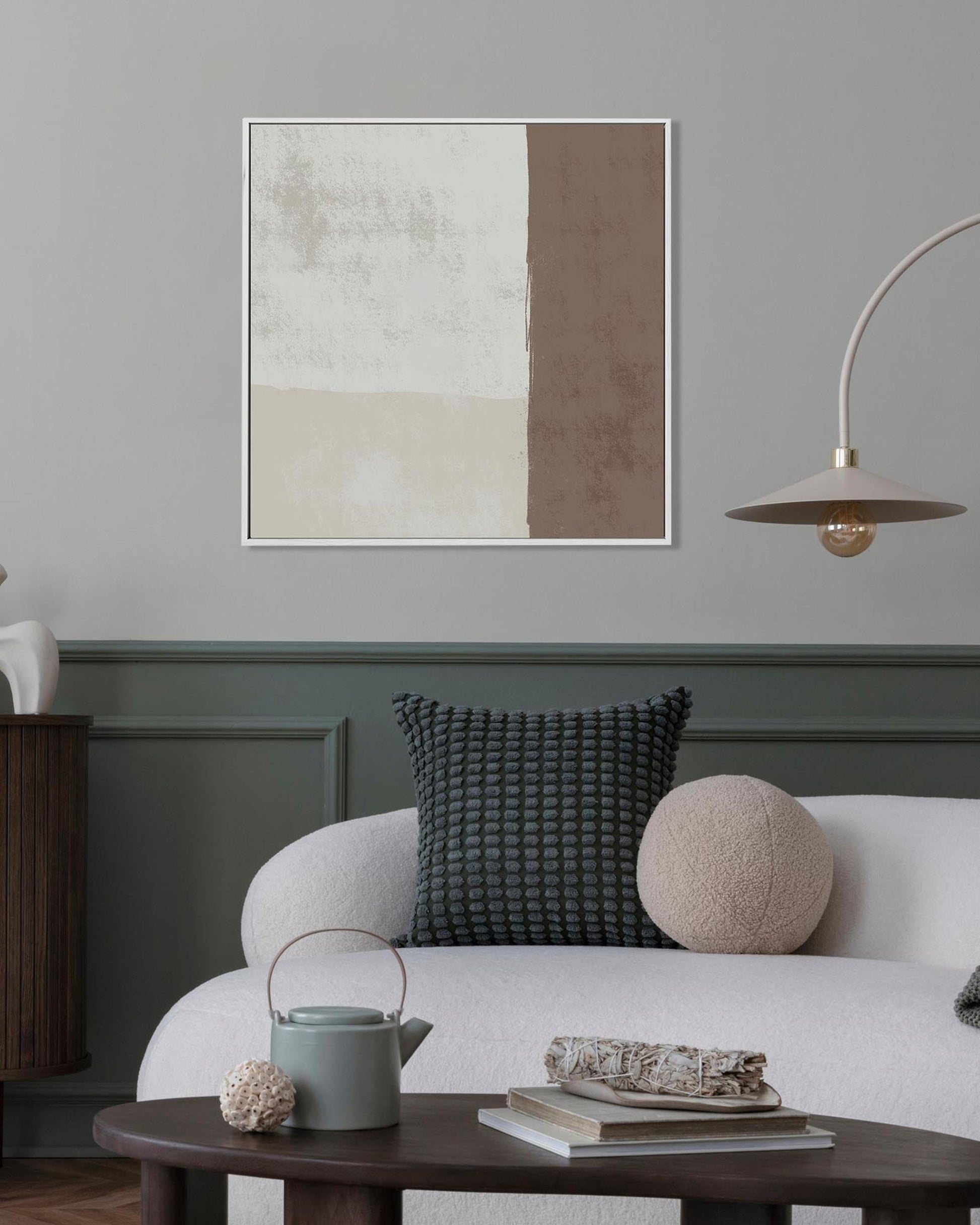 Living room with a white sofa, abstract art on the wall, and a wooden coffee table.