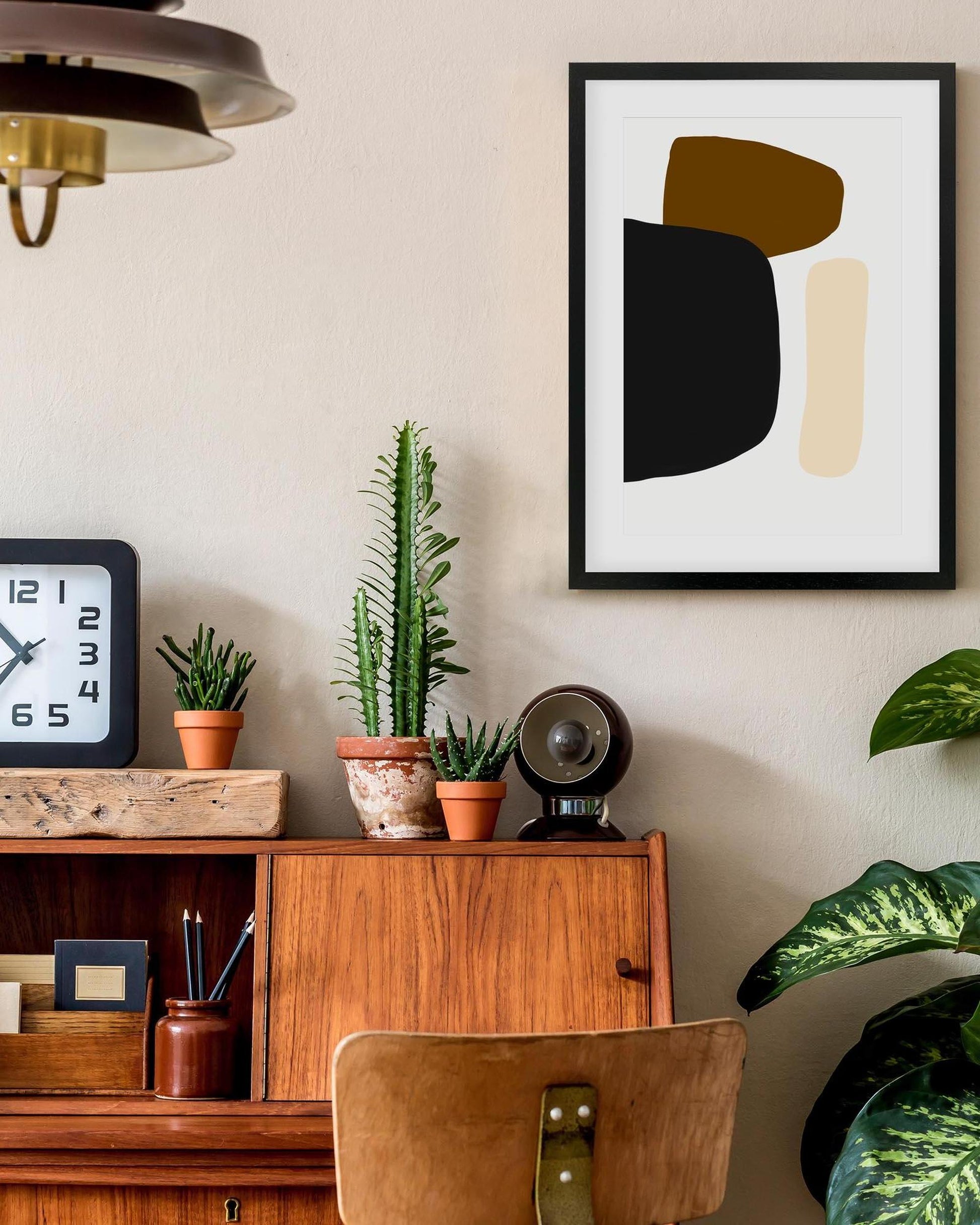 Modern interior with wooden cabinet, plants, and abstract art on the wall.