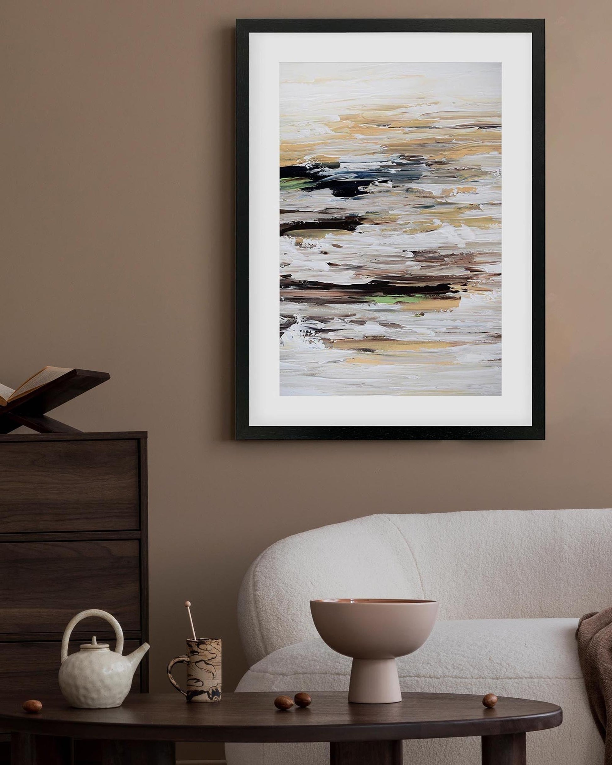 Framed abstract art piece on a wall above a sofa and coffee table.