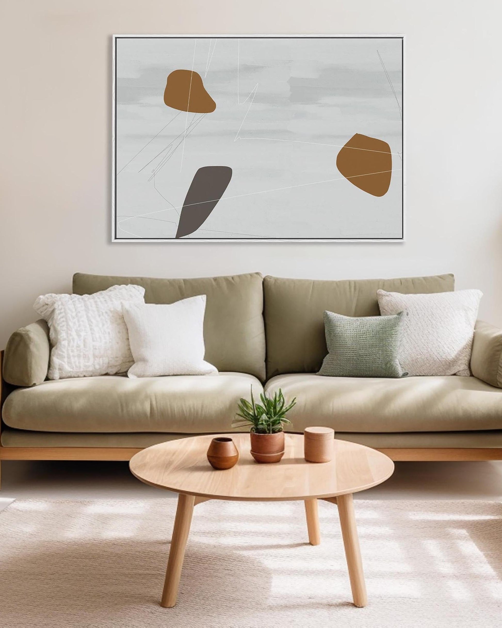 Modern living room with a beige sofa, wooden coffee table, and abstract art on the wall.