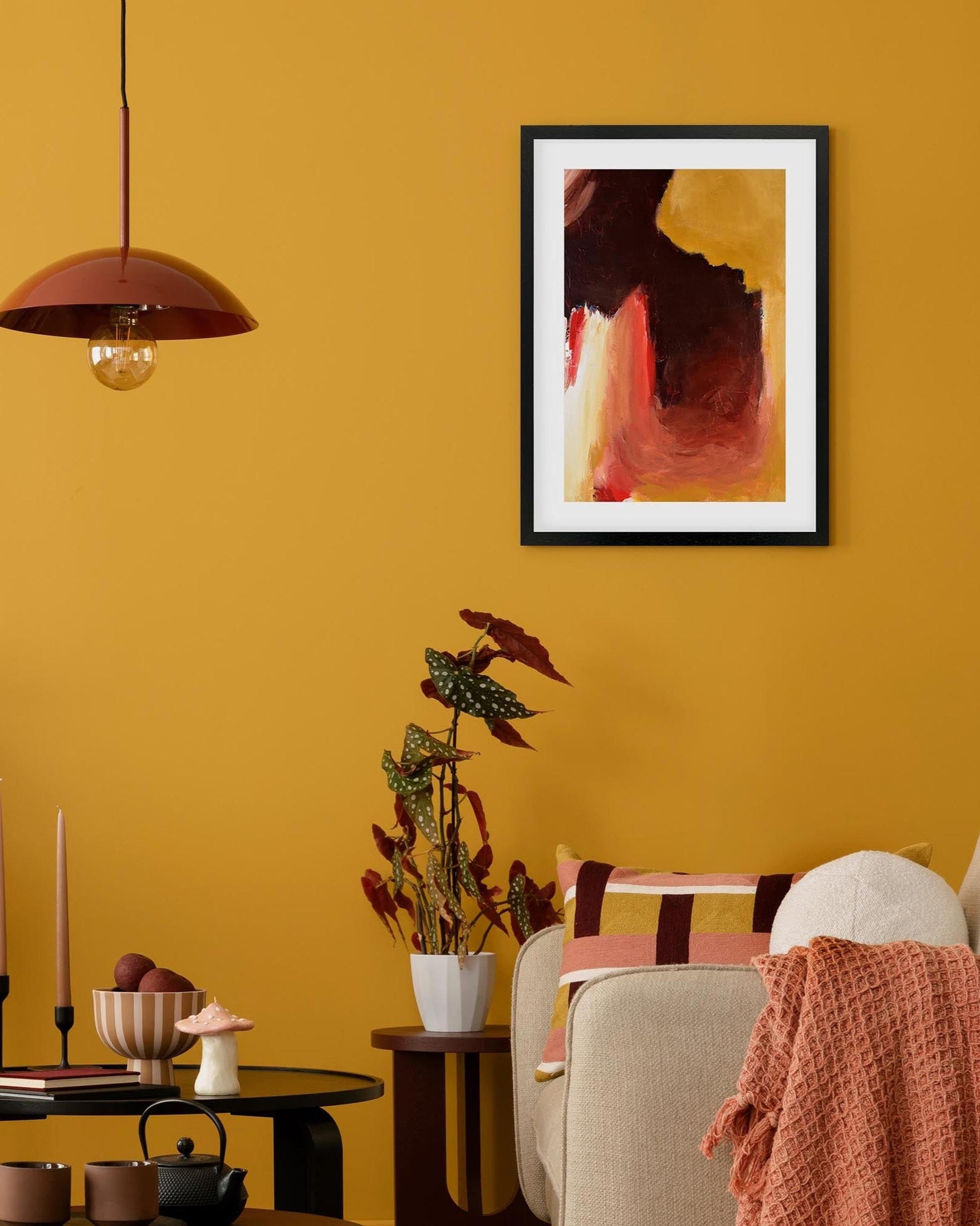 Living room with yellow walls, a framed abstract painting, and decorative items.