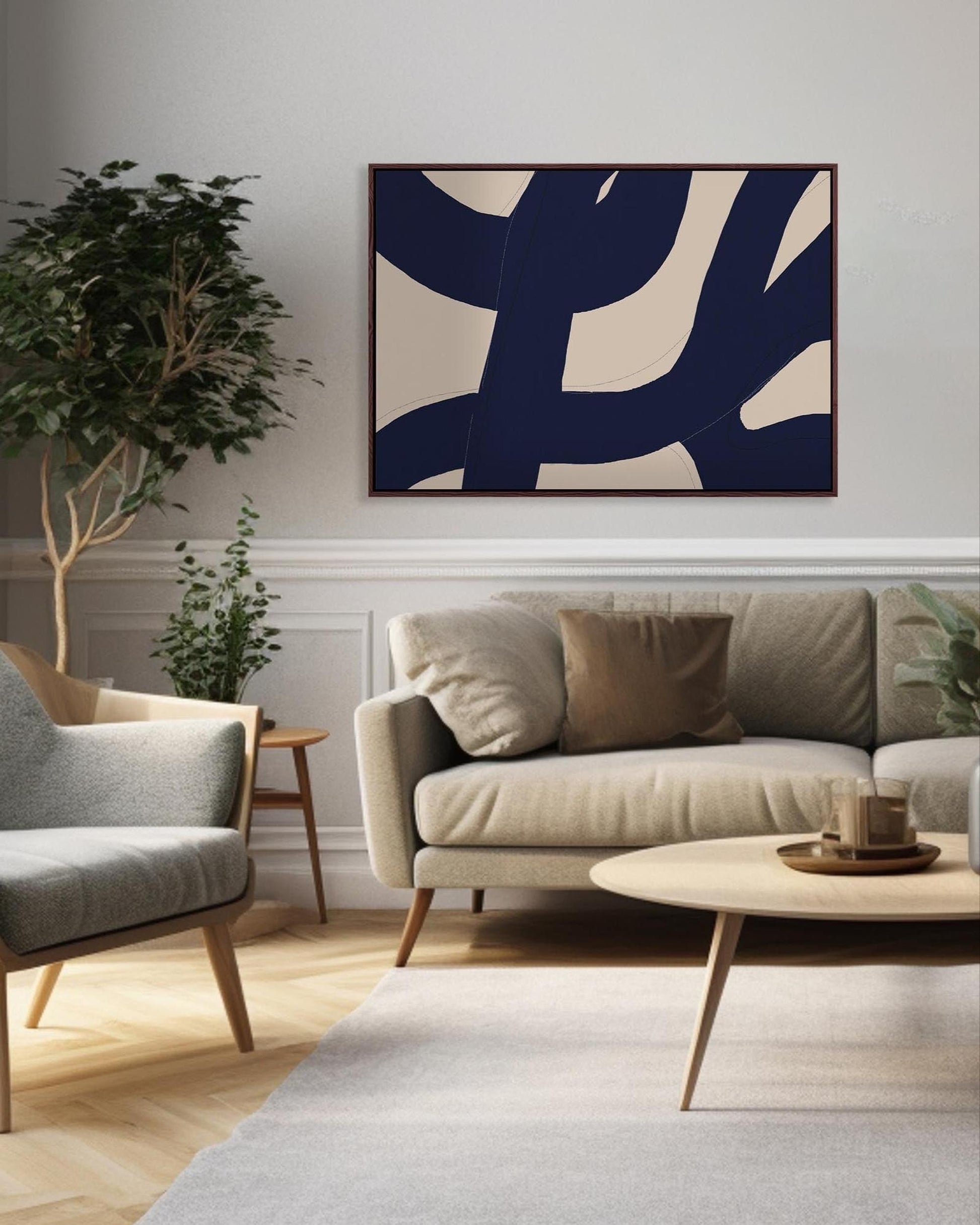 Modern living room with a beige sofa, gray armchair, and abstract art on the wall.