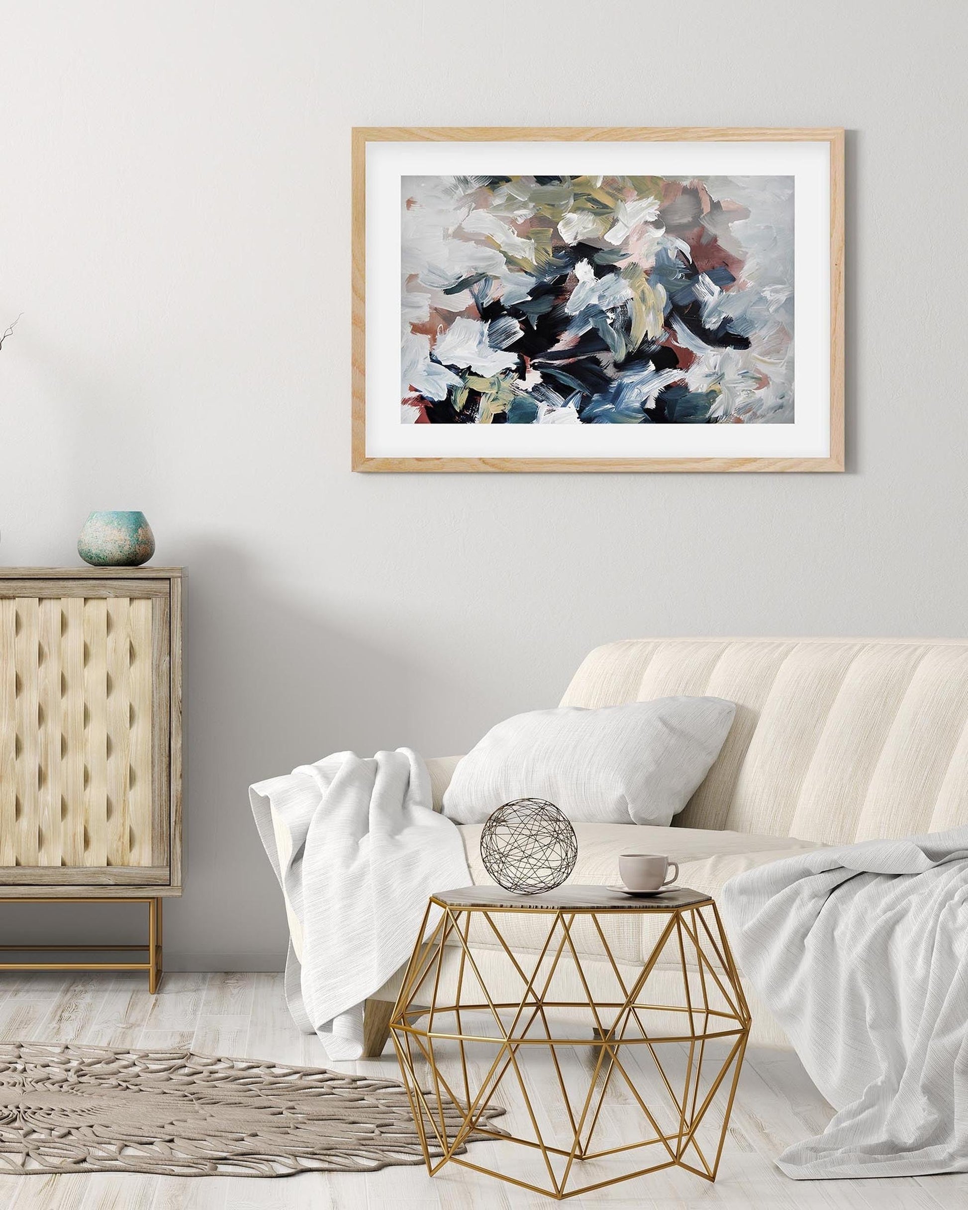 Living room with abstract art on the wall, side table, and decorative items.