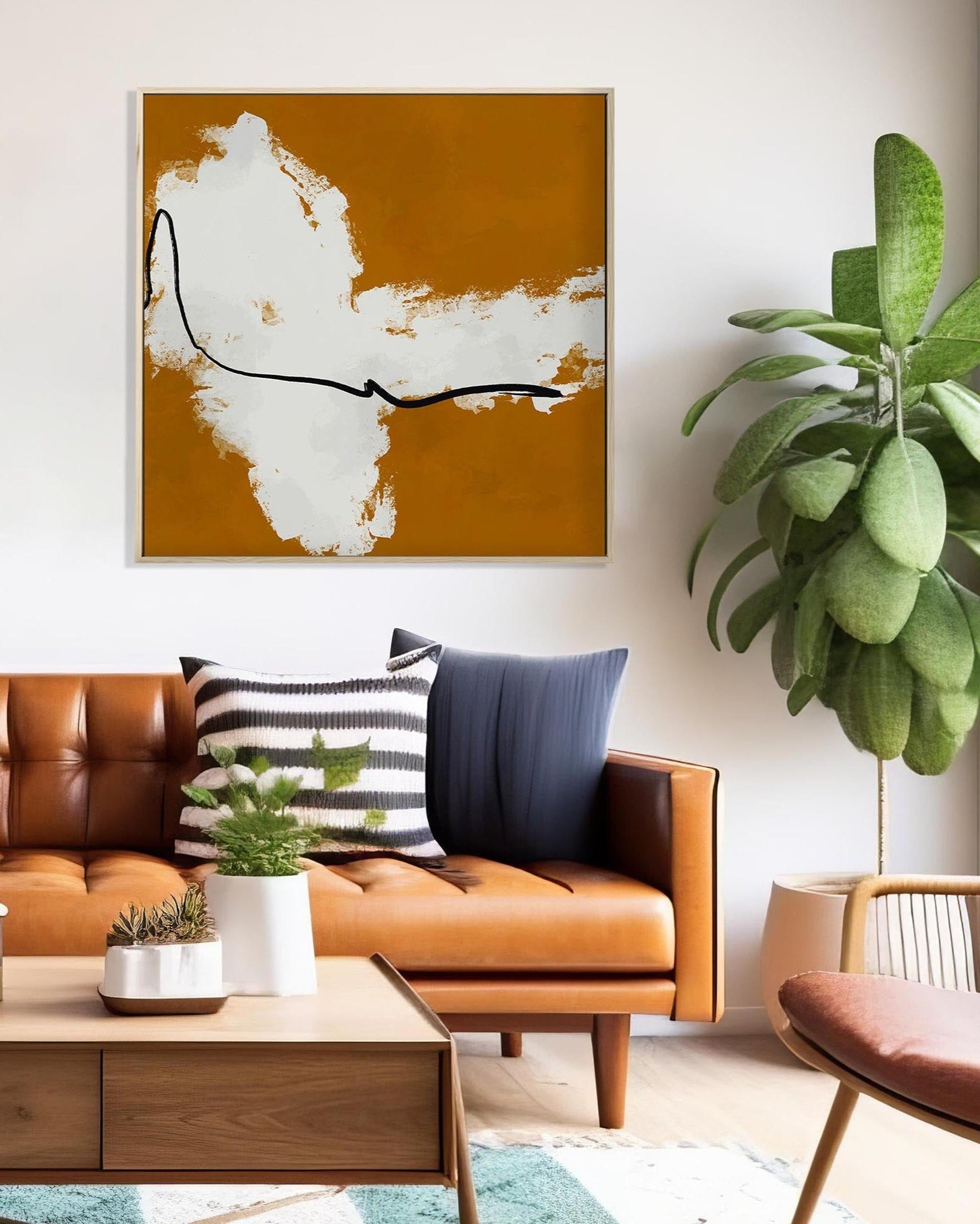 Modern living room with brown leather sofa, wooden coffee table, and abstract art on wall.