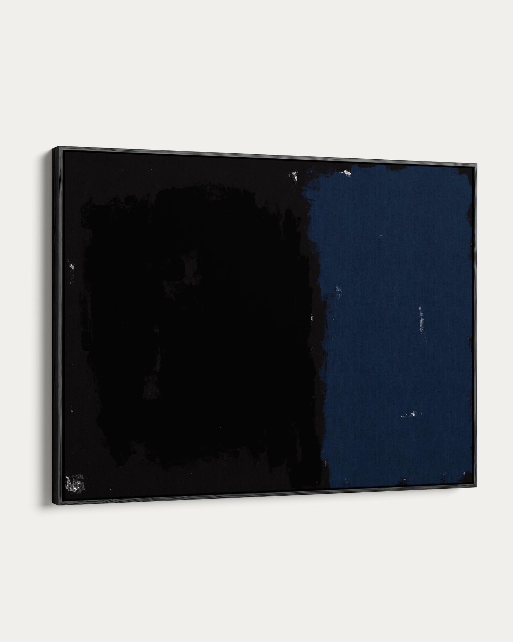 Black-framed abstract painting on a white wall