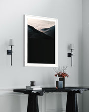 Framed abstract art piece on a wall above a console table with decor items.