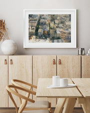Dining room with wooden furniture, a framed abstract painting on the wall, and a small table with cups.