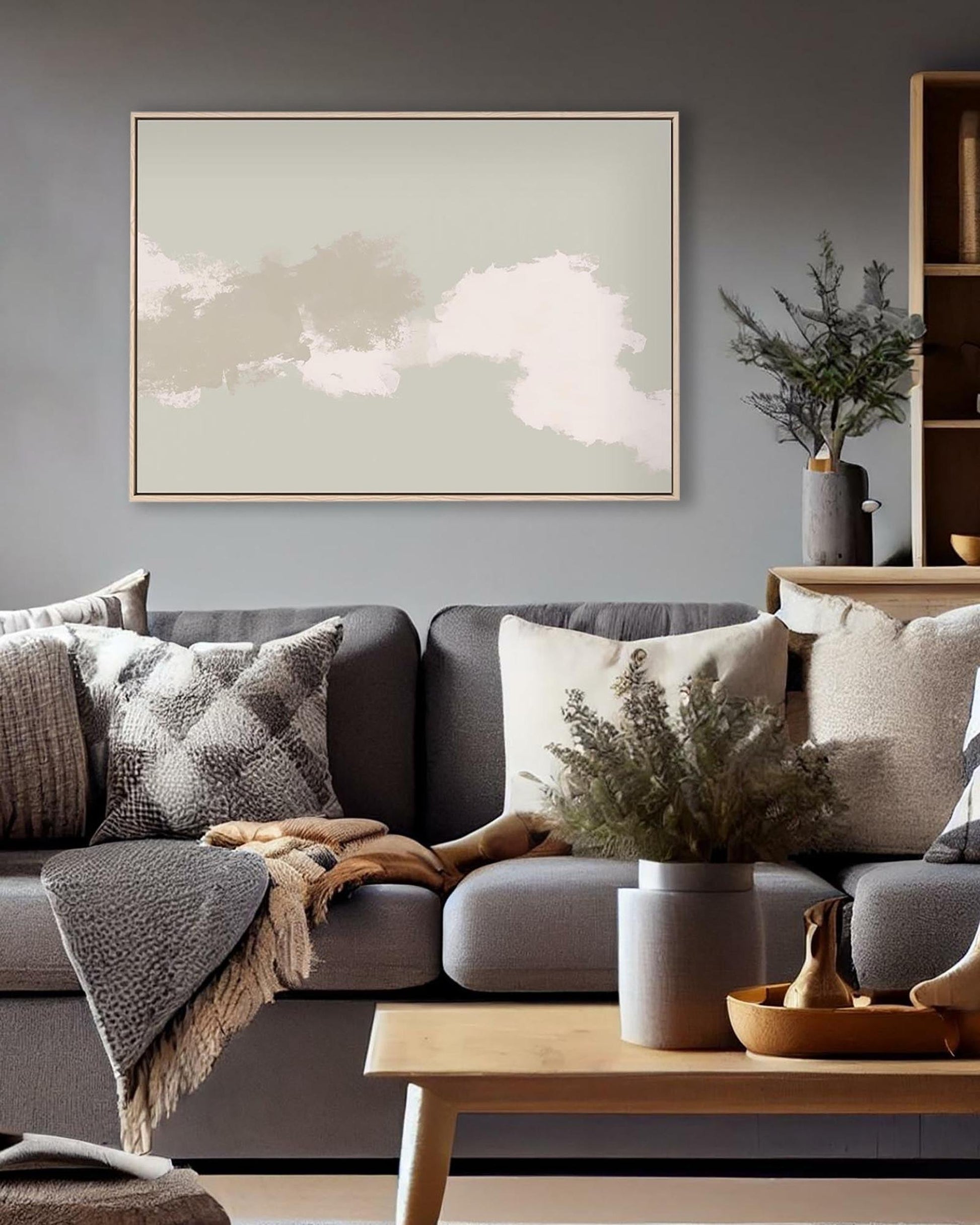 Cozy living room with a gray sofa, decorative pillows, and a framed abstract painting on the wall.