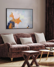 Living room with a brown sofa, wooden coffee table, and abstract art on the wall.