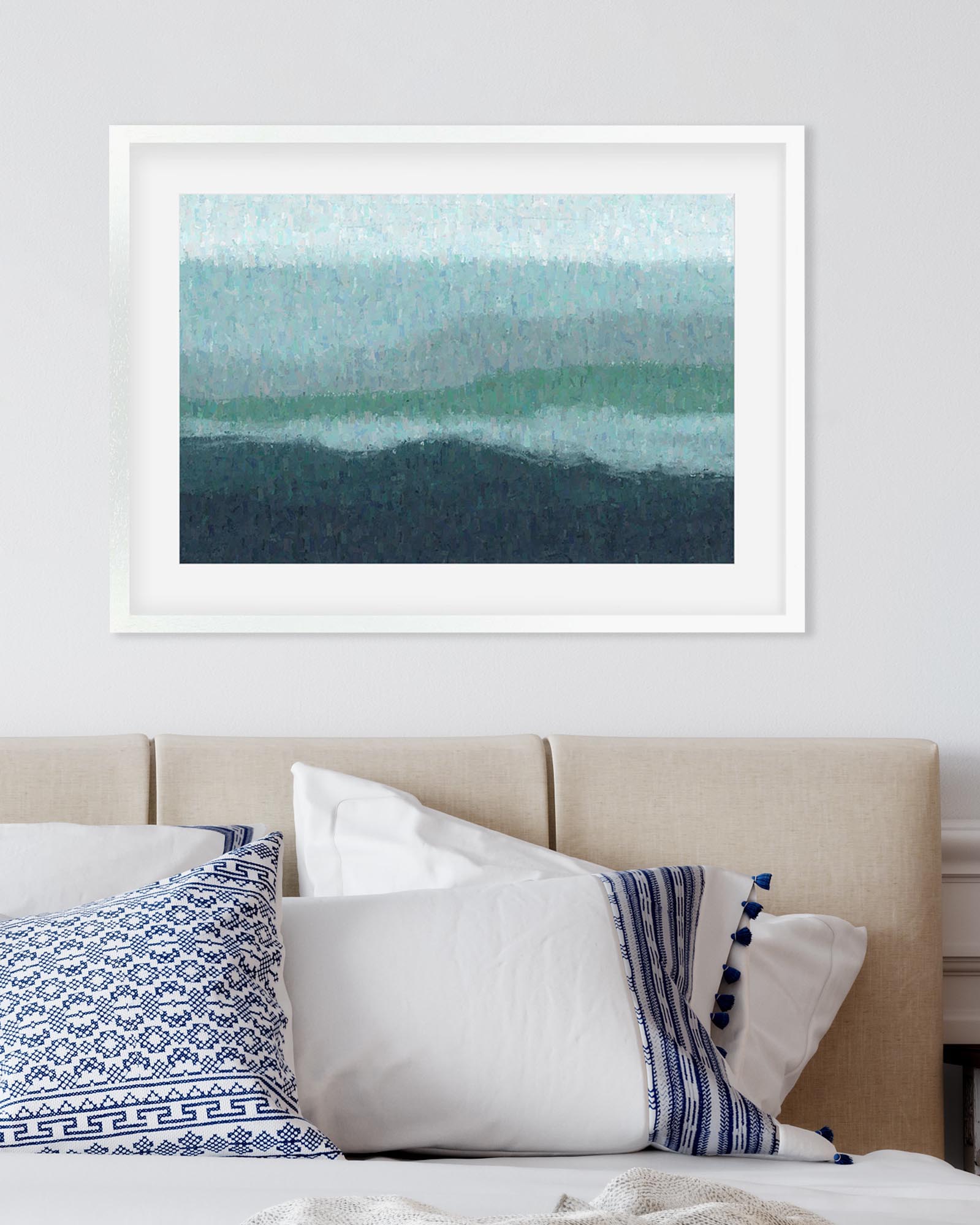Framed abstract art above a bed with decorative pillows