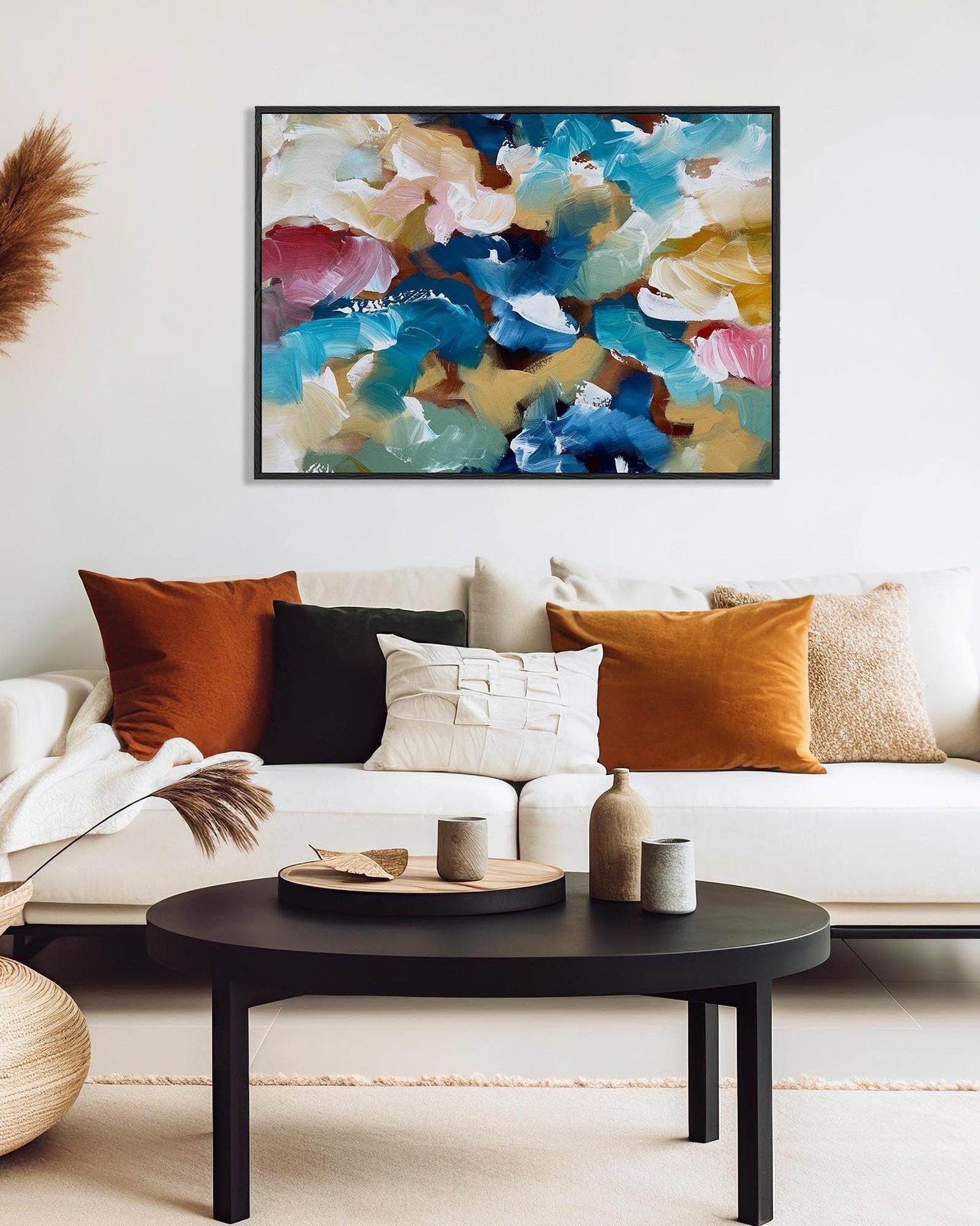 Living room with a colorful abstract painting above a white sofa with patterned cushions.