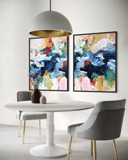 Dining room with a white table, gray chairs, and abstract art on the wall.