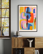 Colorful abstract art on a wall with a wooden cabinet and window in the background