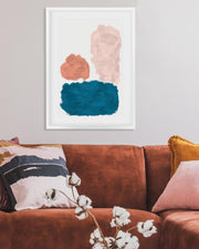 Framed abstract art above a brown sofa with decorative pillows and a plant.