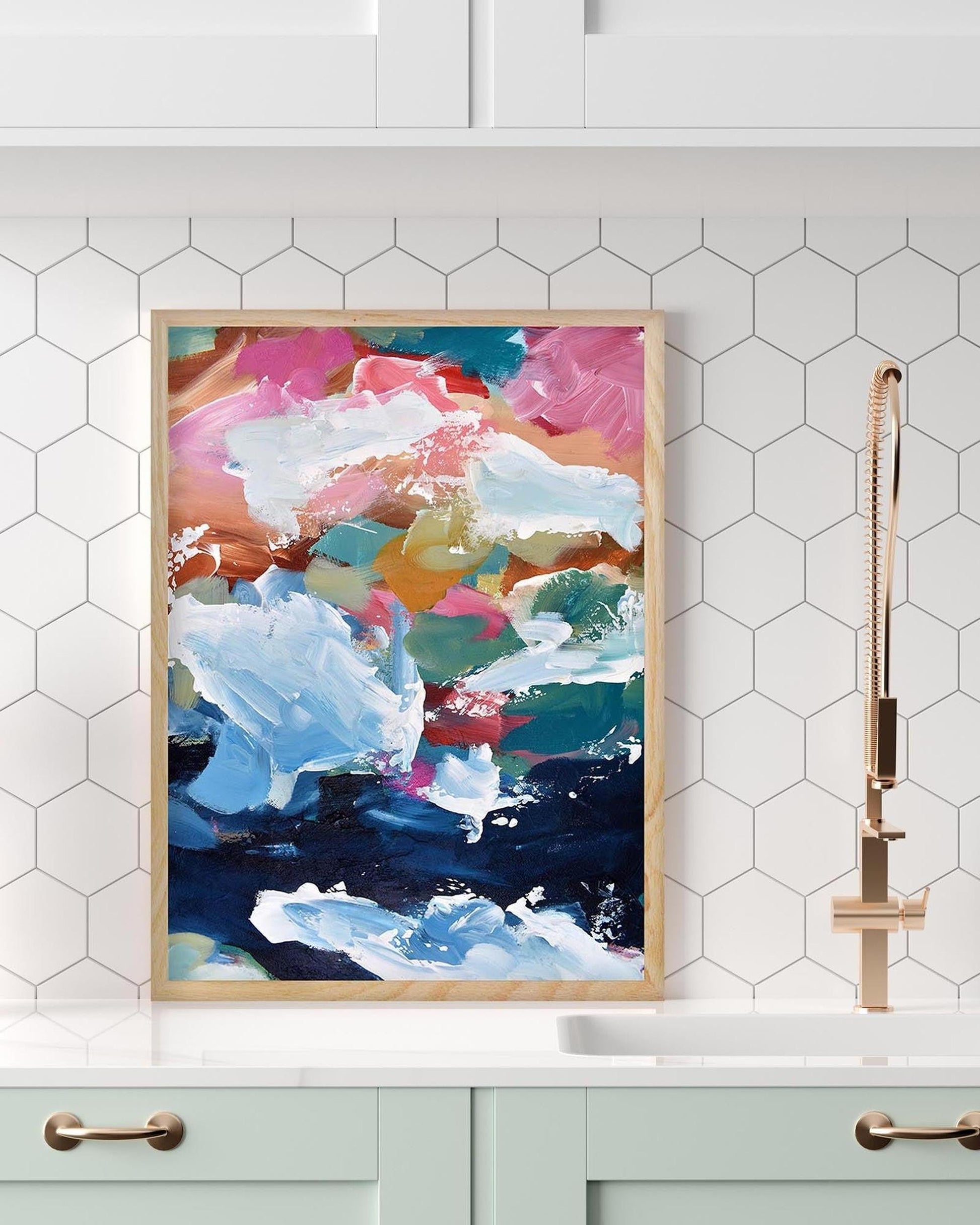 Colorful abstract painting in a wooden frame on a white wall with hexagonal tiles.