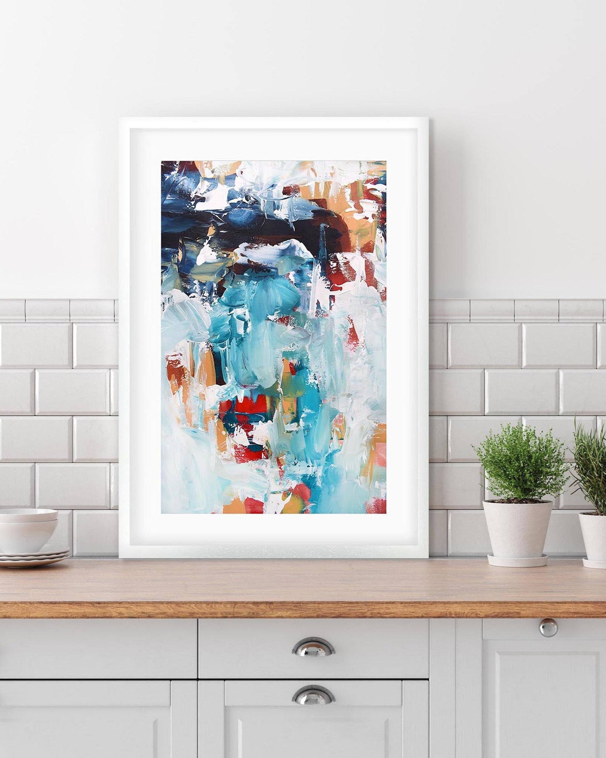 framed abstract print in a white frame in the kitchen 
