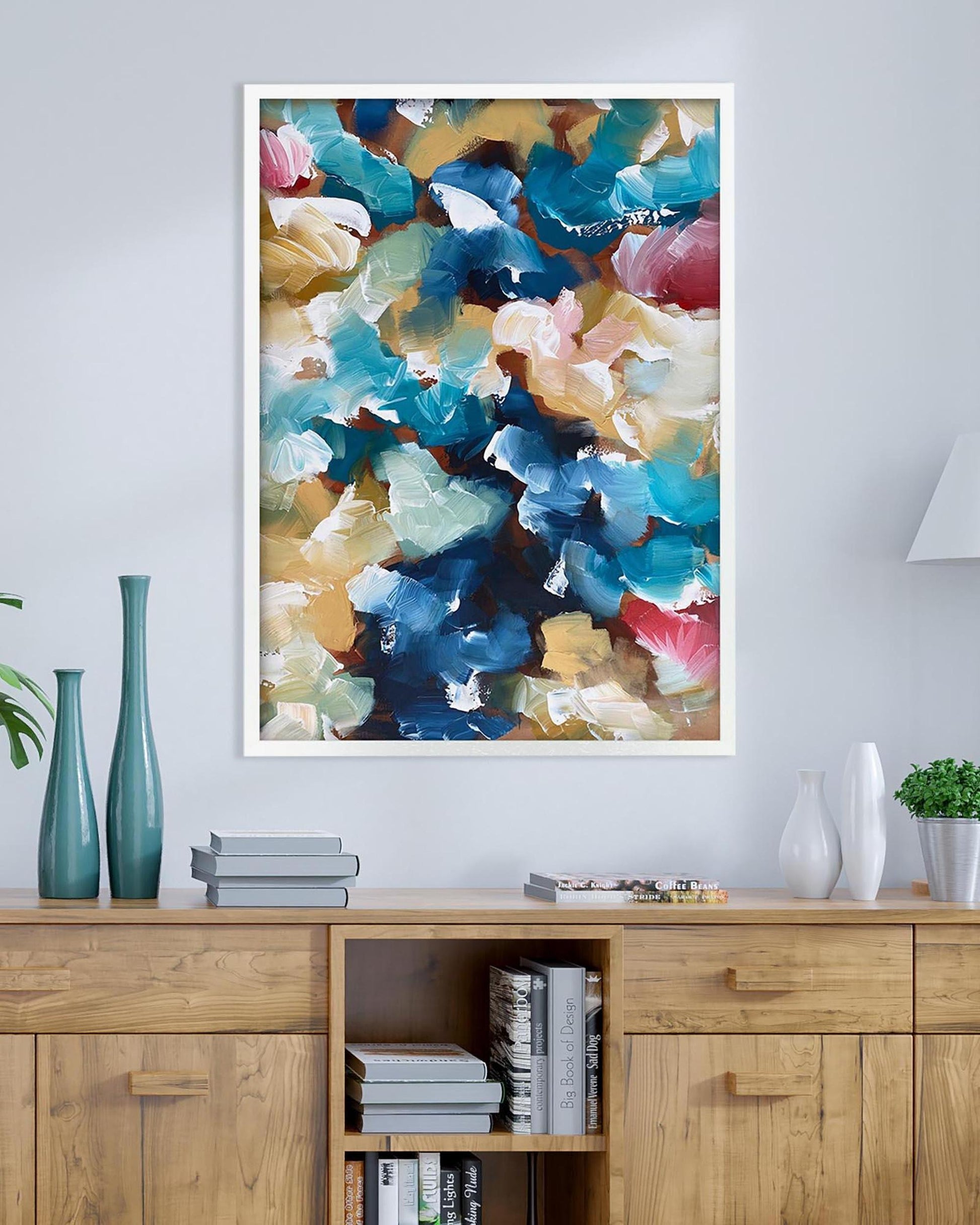 Colorful abstract painting on a wall above a wooden cabinet with decorative items.