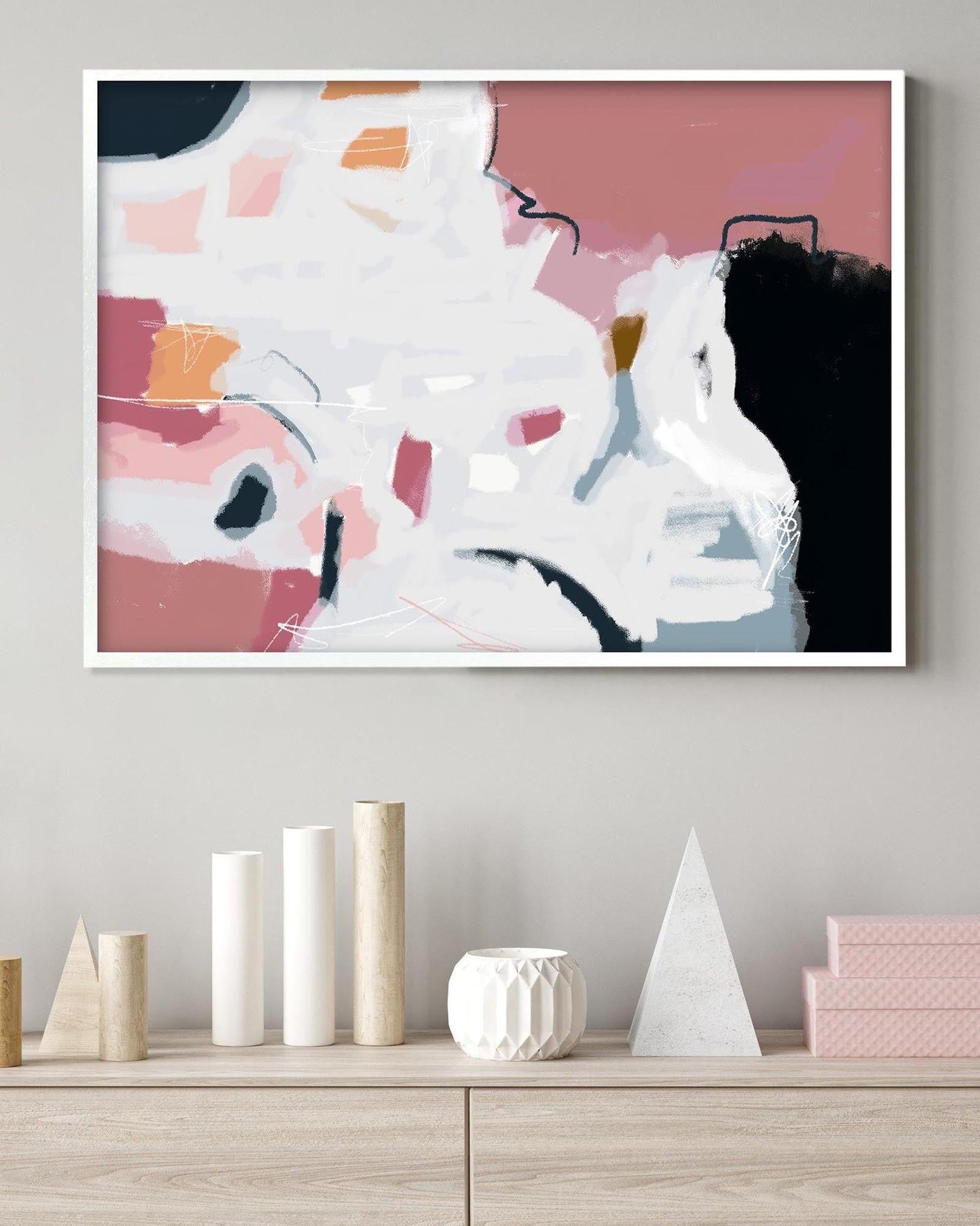 Abstract art print on a wall above a wooden shelf with decorative items.