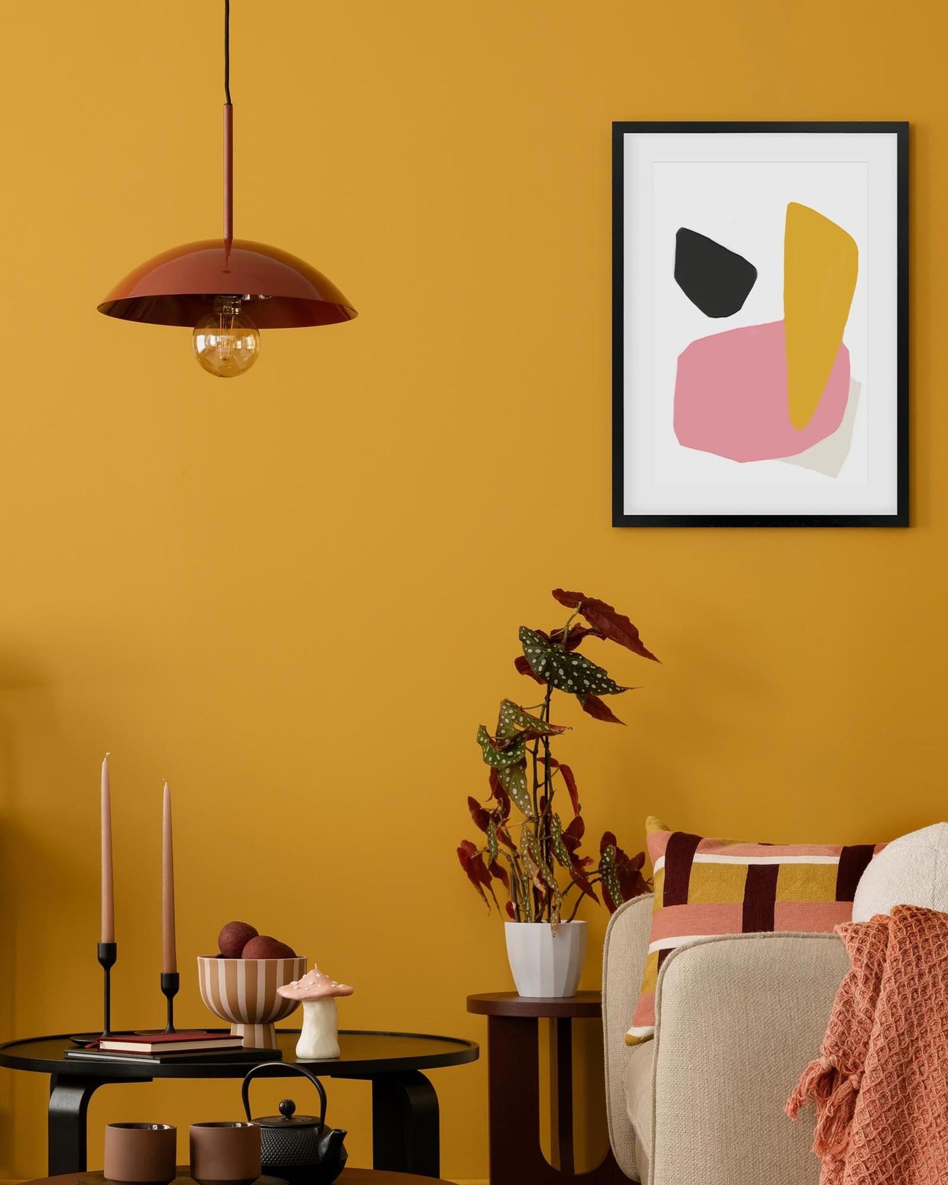 Living room with abstract art on a yellow wall, modern decor, and a cozy atmosphere.