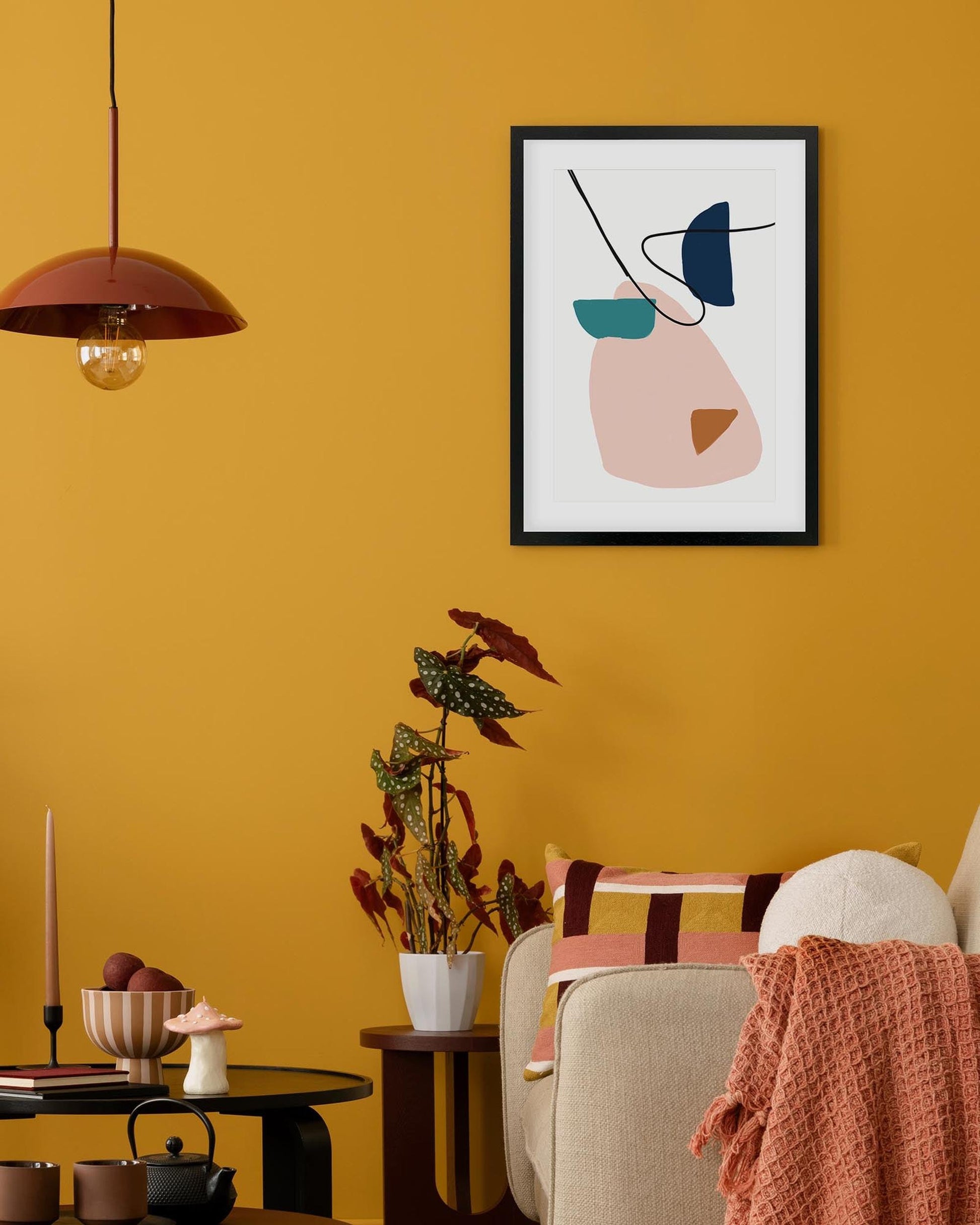 Living room with yellow walls, a framed abstract art piece, and decorative items.
