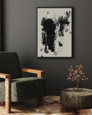 Modern interior with a green armchair, abstract art, and decorative plant.