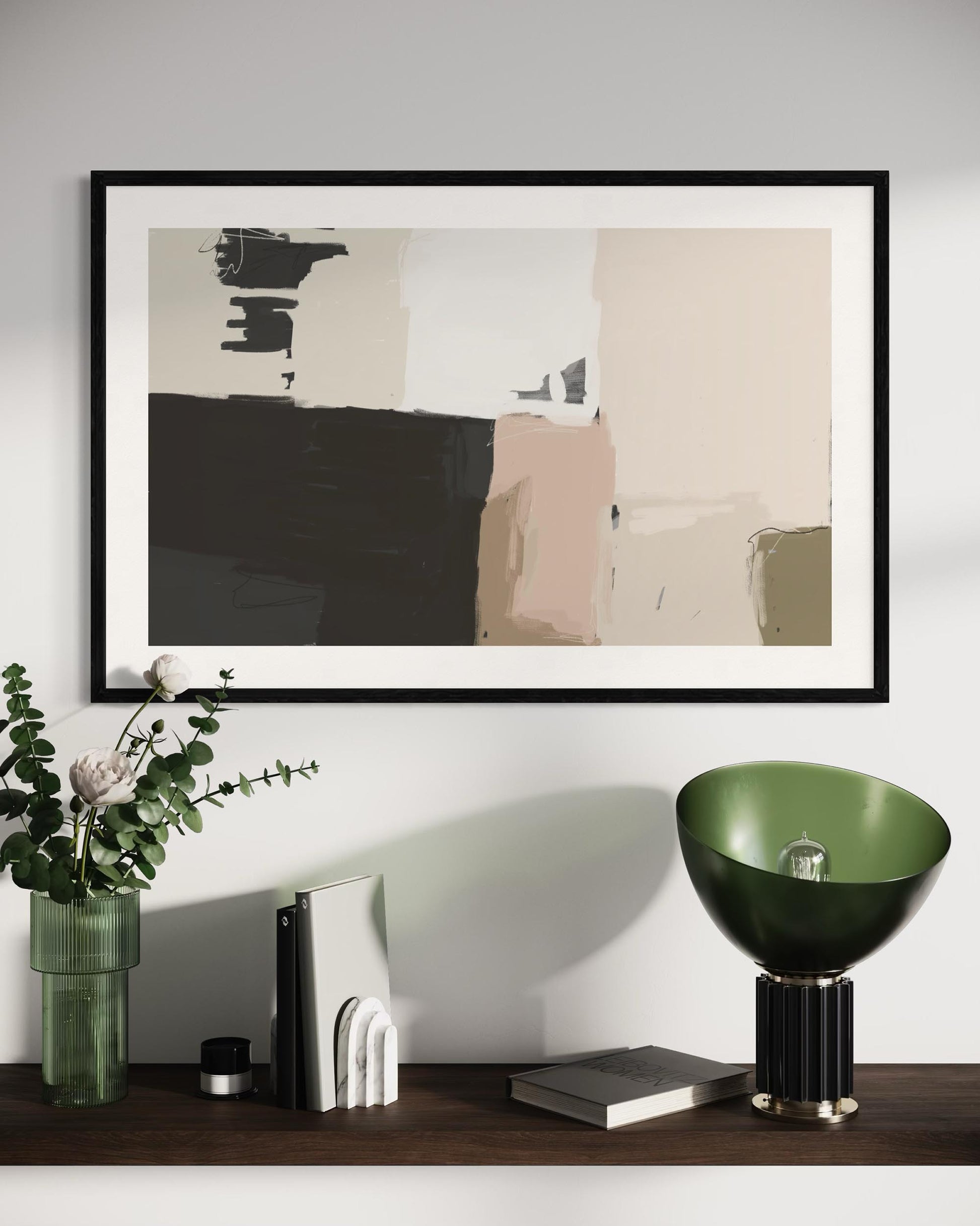 Abstract art piece in a black frame on a wall above a wooden shelf with decorative items.