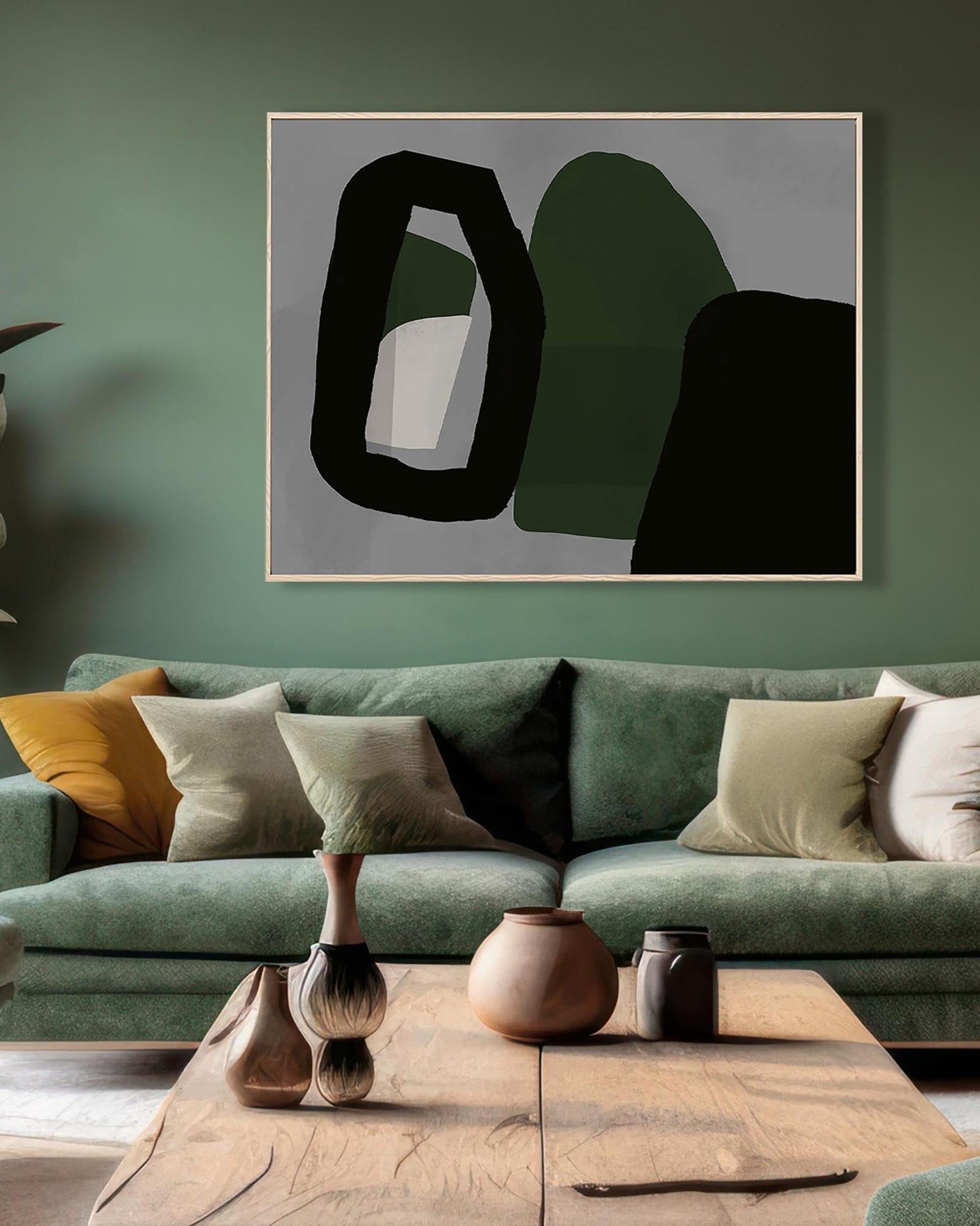 Abstract art piece on a green wall above a green sofa with decorative pillows.