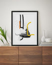 Abstract art print in a black frame on a wooden surface with decorative items.