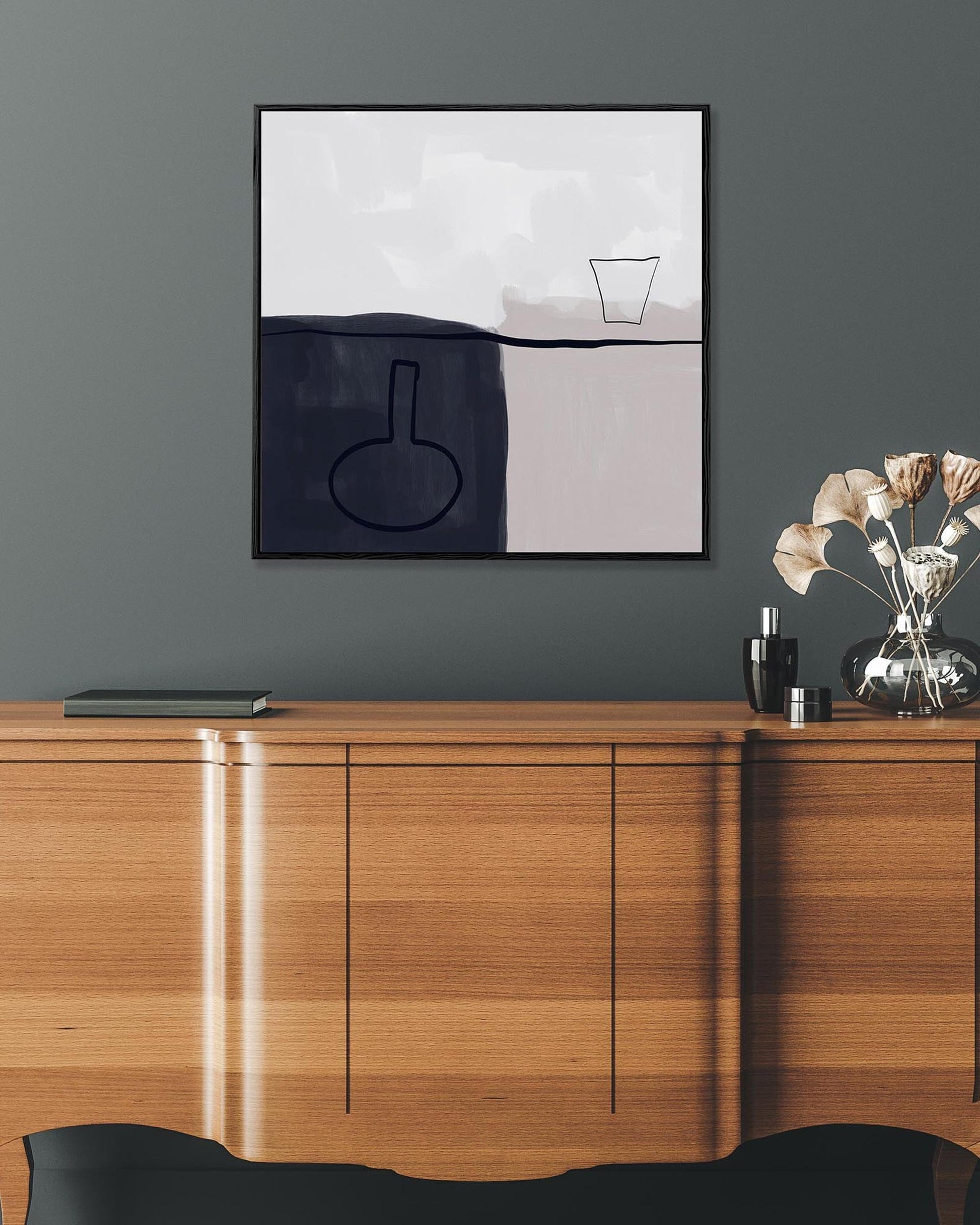 Abstract art piece on a gray wall above a wooden cabinet.