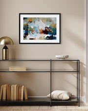 Framed abstract painting on a wall above a black metal console table with decorative items.