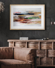 Framed abstract painting on a dark wall above a brown sofa and wooden cabinet.