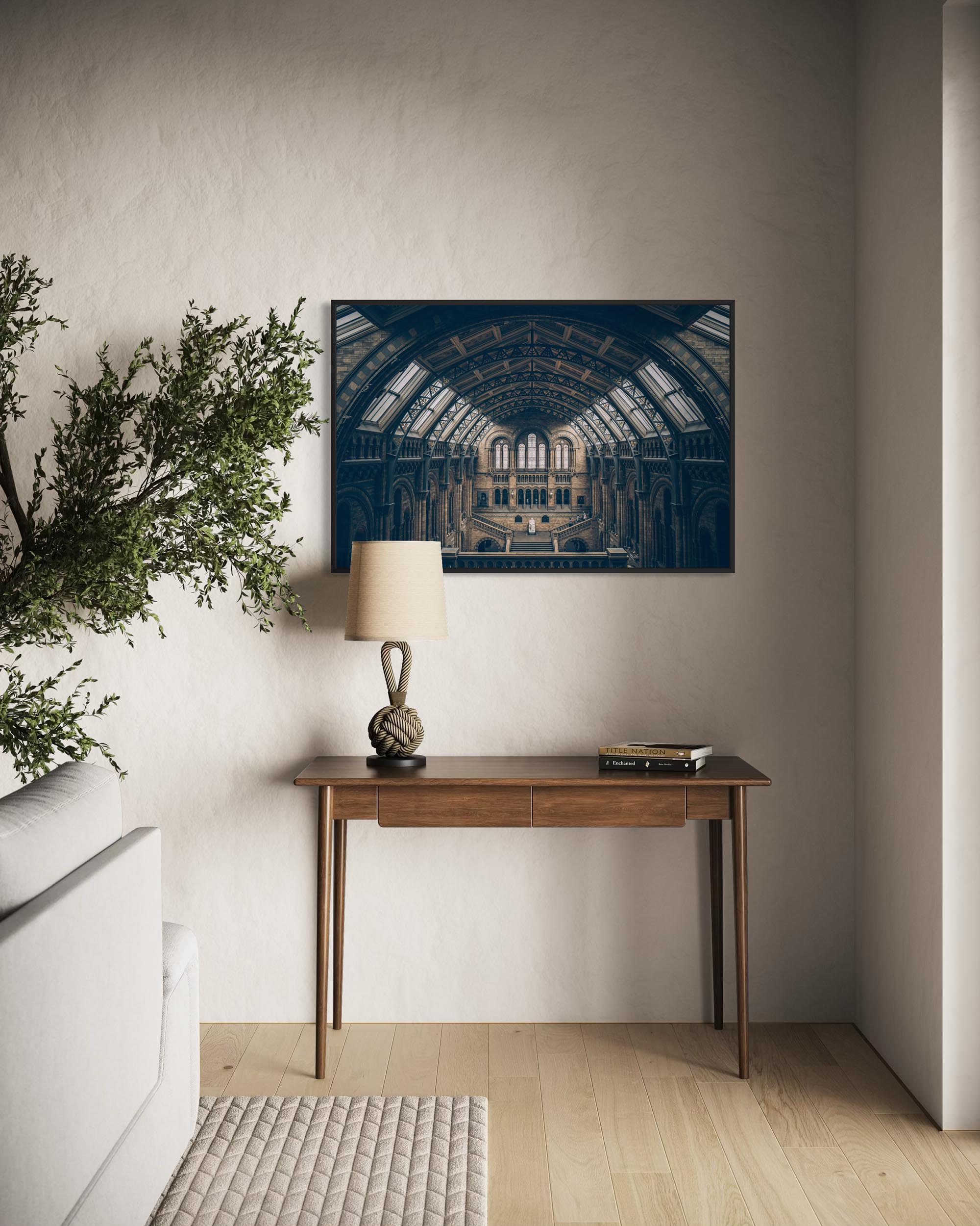 Modern interior with a wooden console table, lamp, and decorative items against a neutral wall.