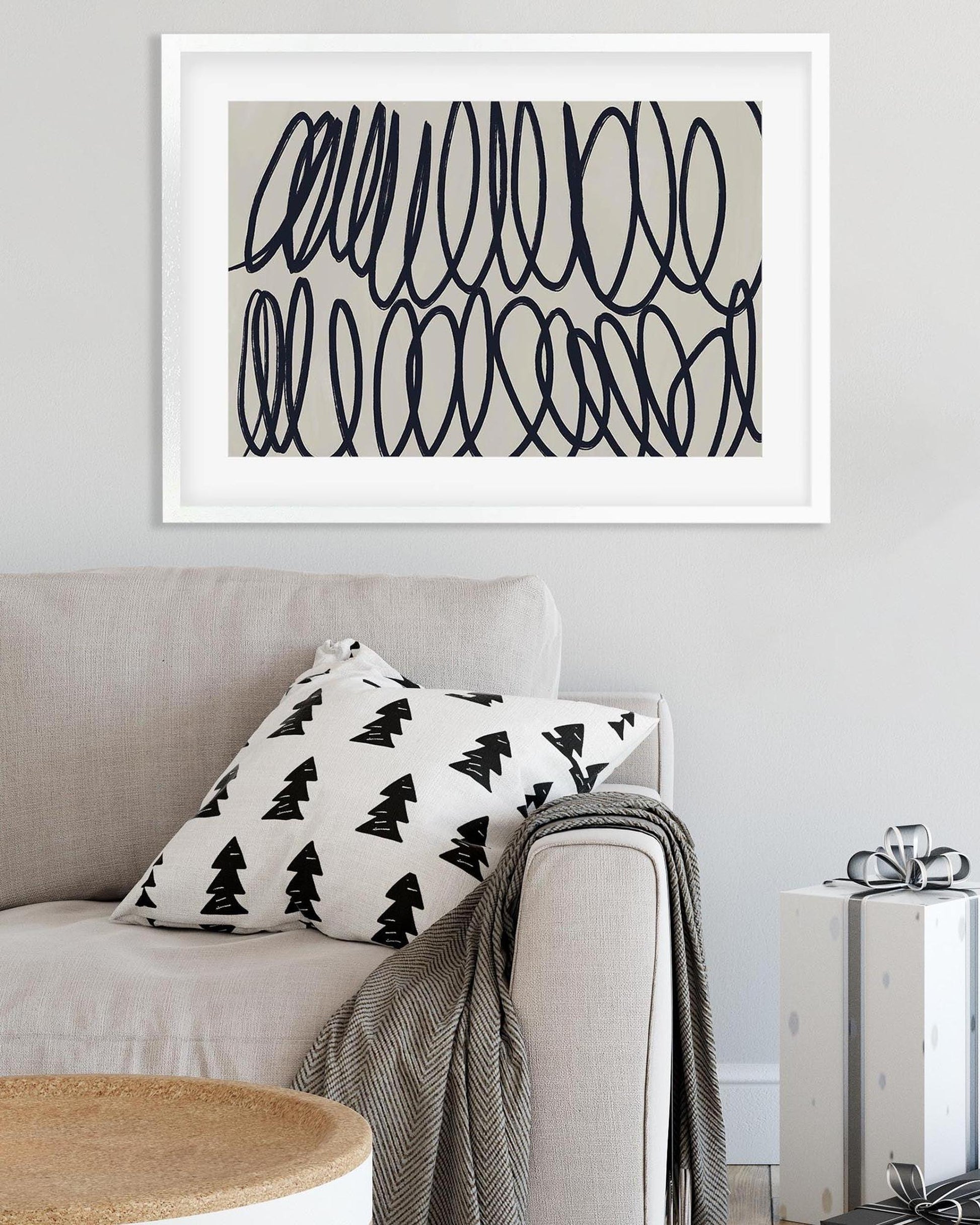 Sofa with decorative pillow and framed abstract art on a wall