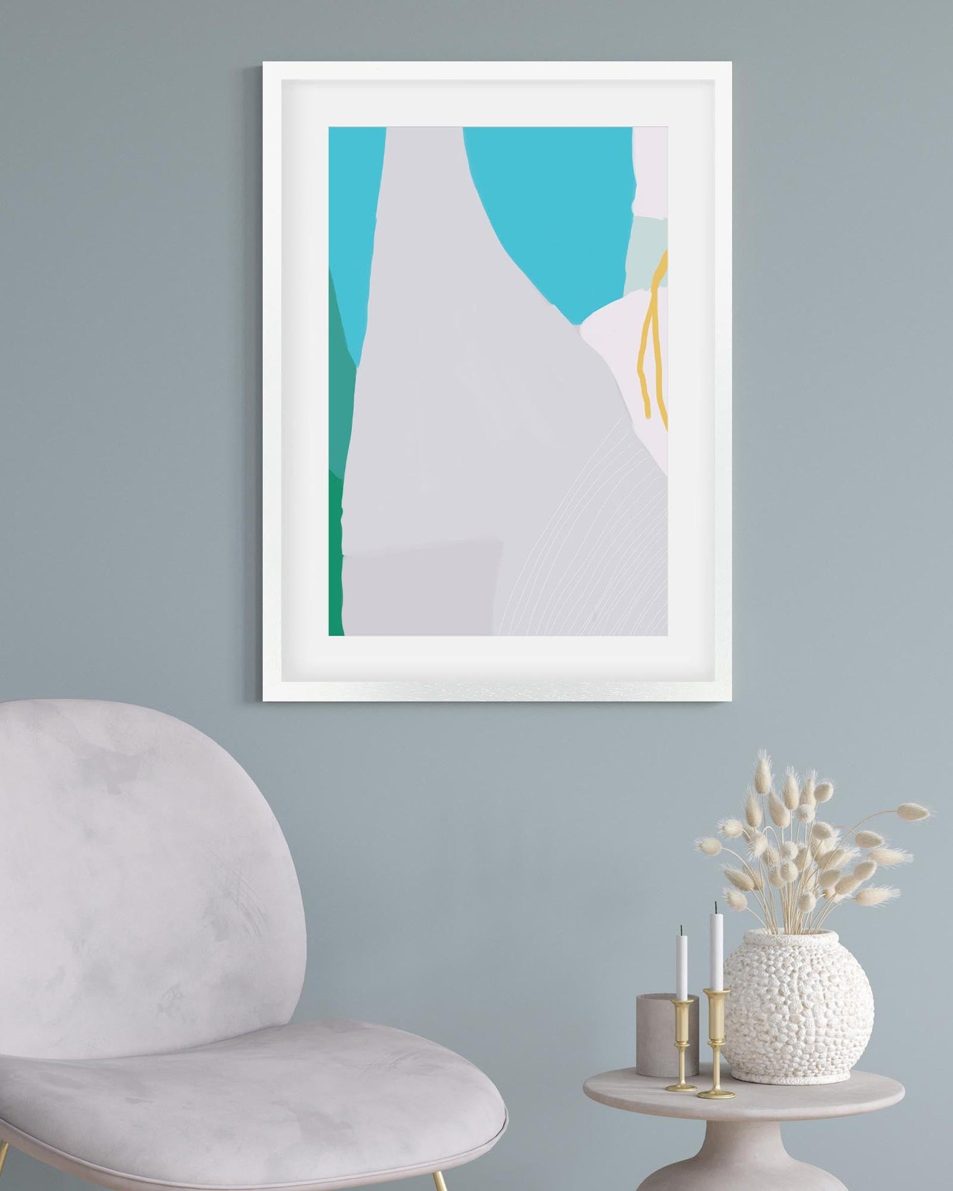 Framed abstract art on a wall with a chair and decorative items below.