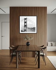 Dining room with wooden table and chairs, framed picture on slatted wall.